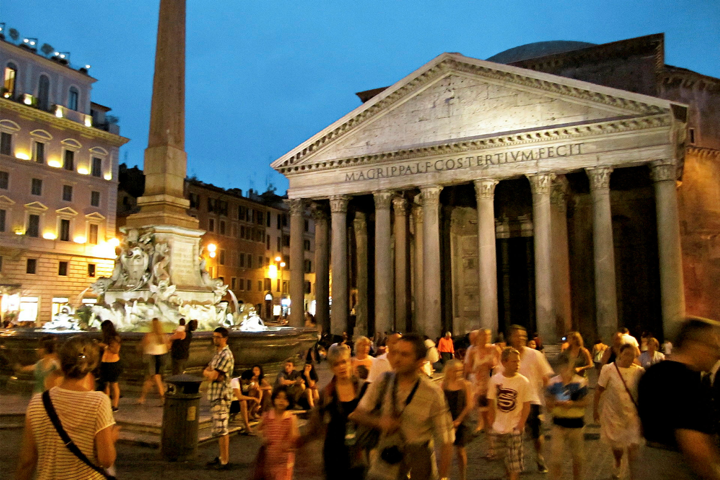 Pantheon i Roma med fontenen foran, omgitt av besøkende på kvelden. (AI-generert tekst)
