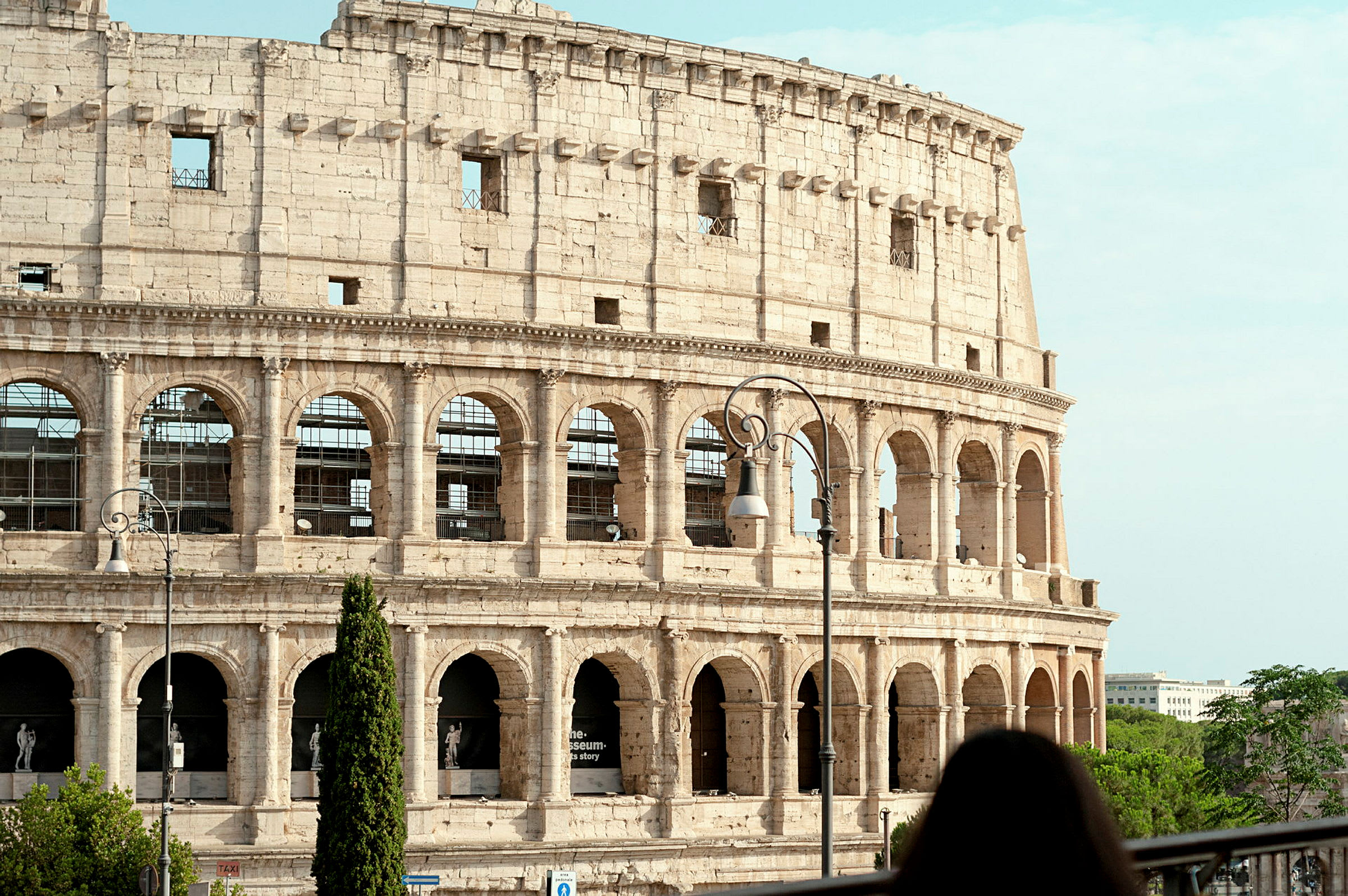 Bilde av Colosseum i Roma, Italia, med en kvinne i forgrunnen. (AI-generert tekst)