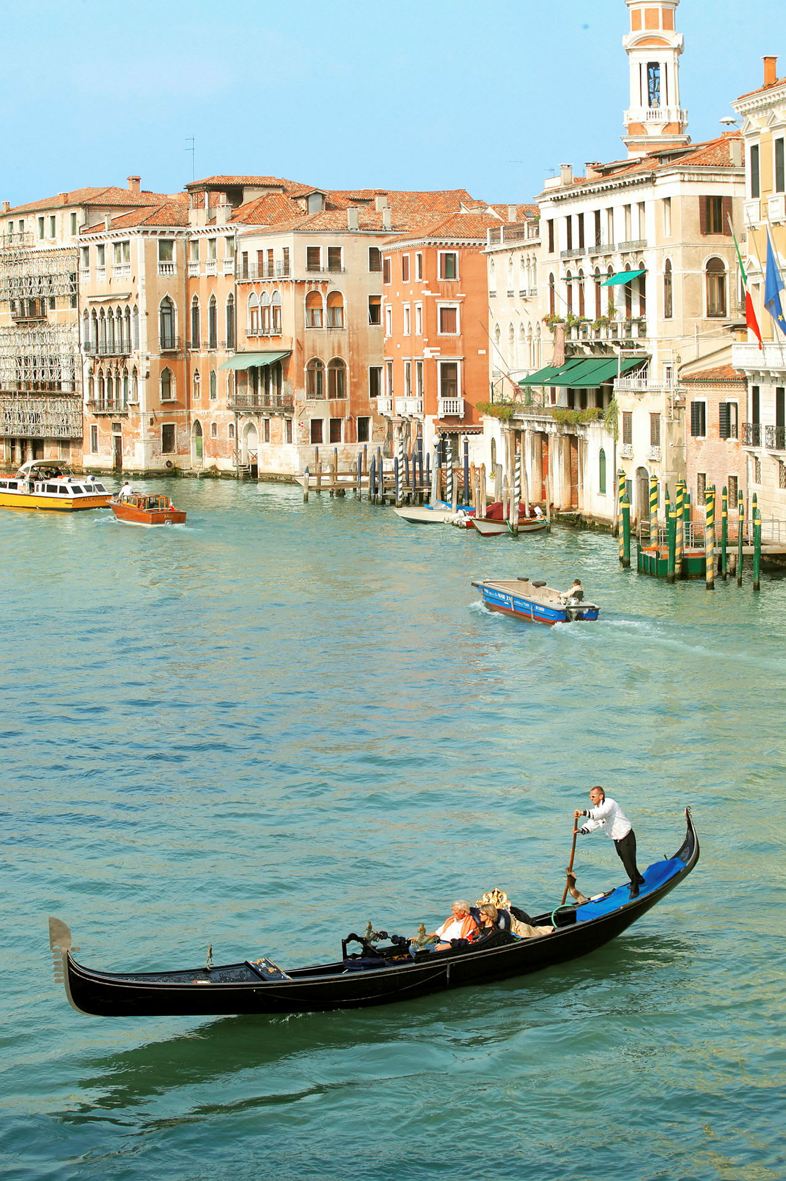 En gondol på en kanal i Venezia med historiske bygninger i bakgrunnen. (AI-generert tekst)