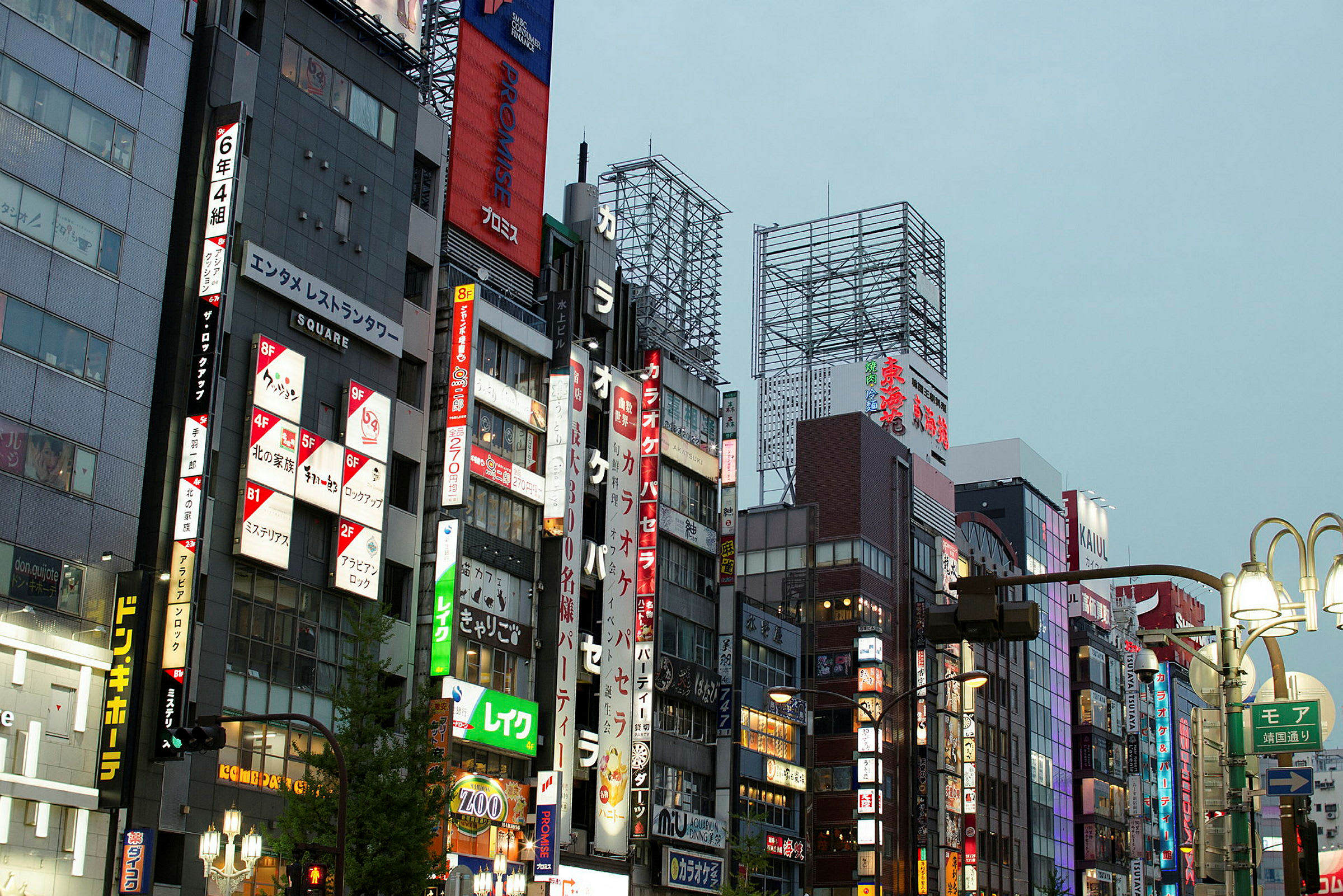Boligblokker langs en gate med opplyste japanske skilt og reklame. (AI-generert tekst)