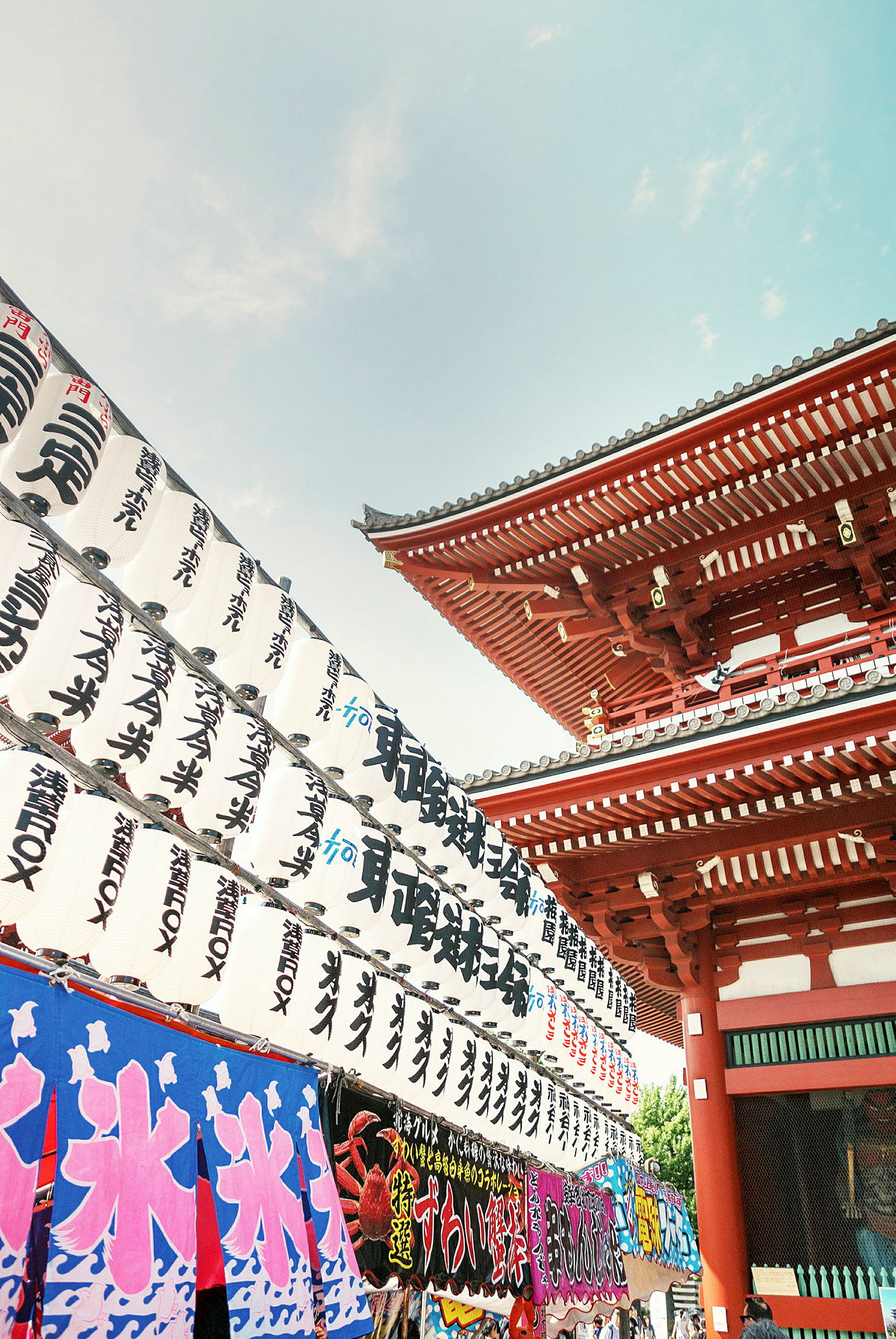 Japansk tempel med røde bygninger og dekorasjoner samt tradisjonelle hvite lanterner med japanske tegn. (AI-generert tekst)