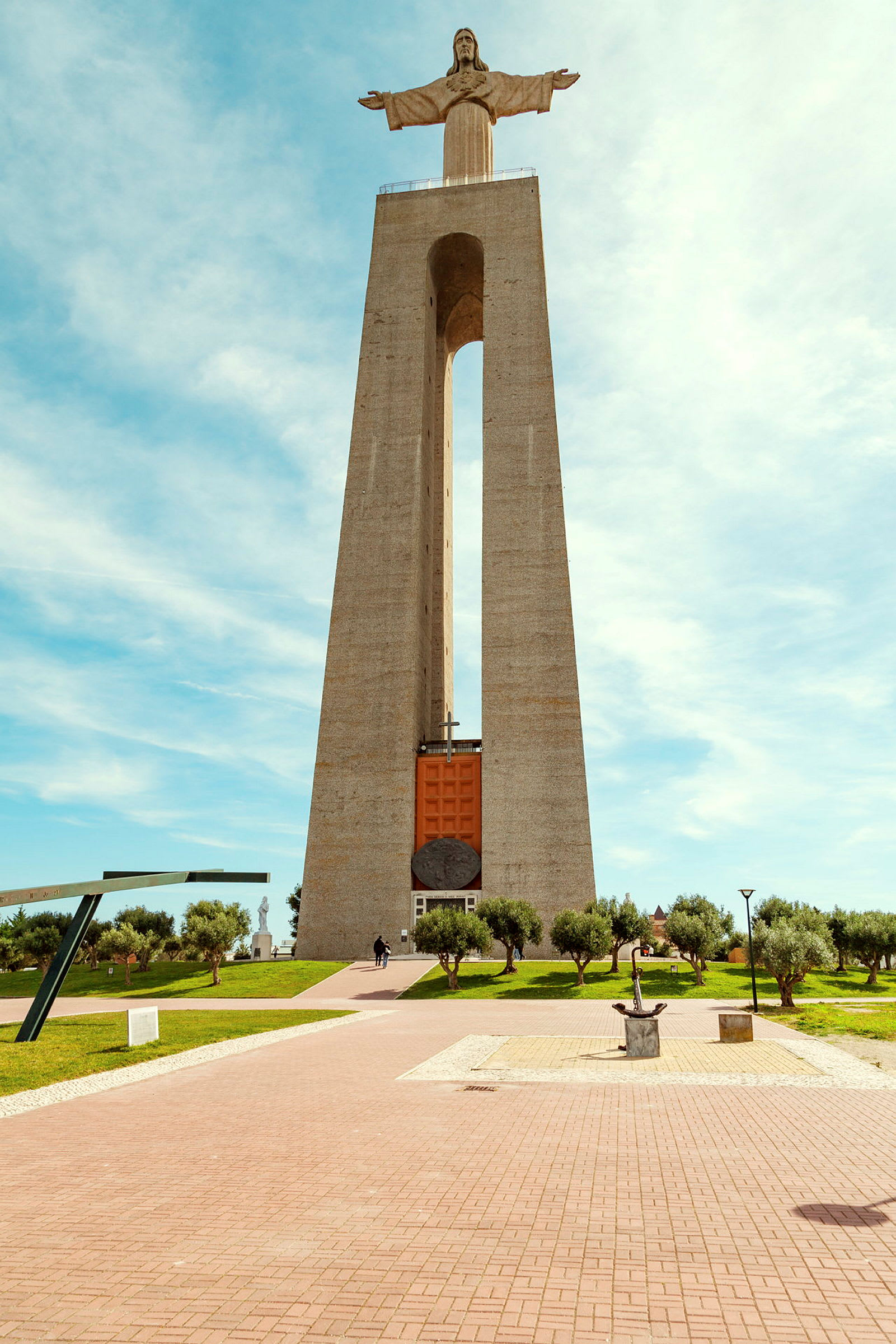 Monument med en Kristusstatue på toppen, omgitt av en park. (AI-generert tekst)