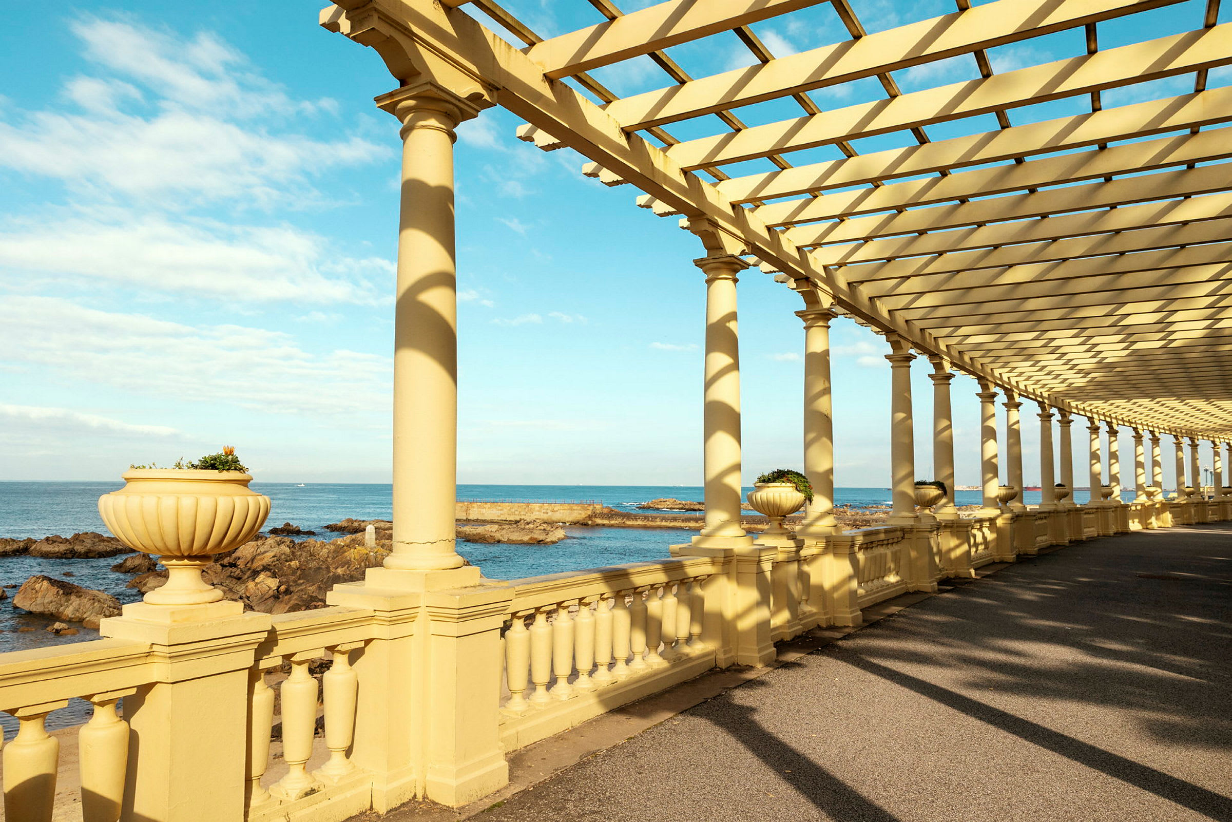 En pergola med utsikt over havet og klipper. (AI-generert tekst)