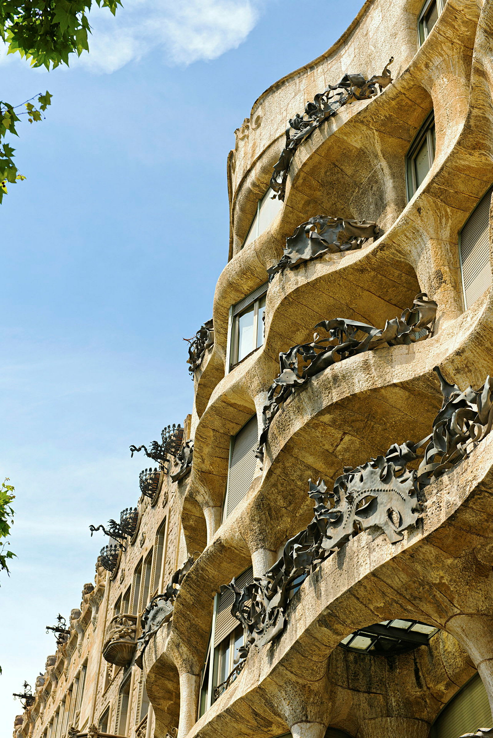 Nærbilde av den bølgende fasaden på Casa Milà, kjent som La Pedrera, i Barcelona. (AI-generert tekst)