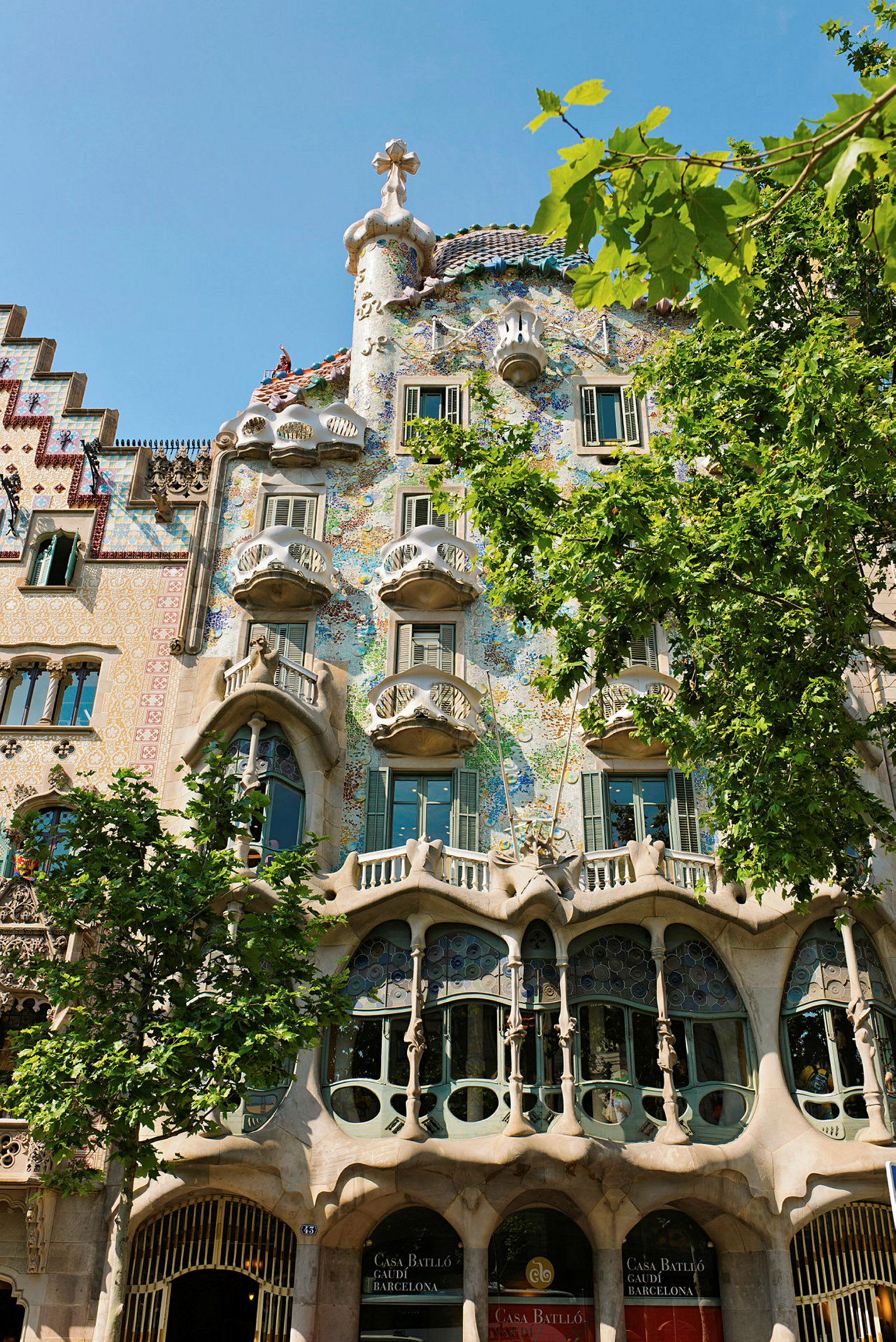 Bilde av Casa Batlló, en ikonisk bygning i Barcelona designet av Gaudí, med sin unike arkitektur og fargerike fasade. (AI-generert tekst)