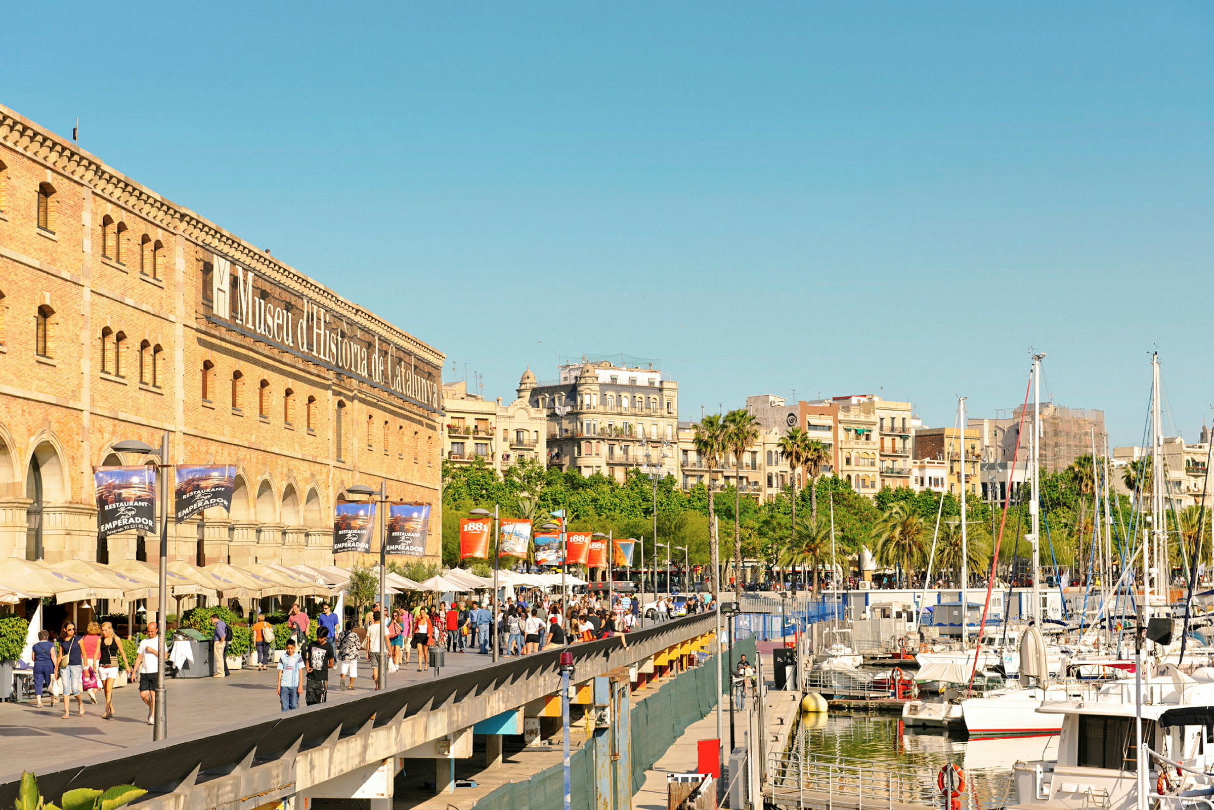 Promenade ved Museu d'Història de Catalunya og båter i en havn. (AI-generert tekst)
