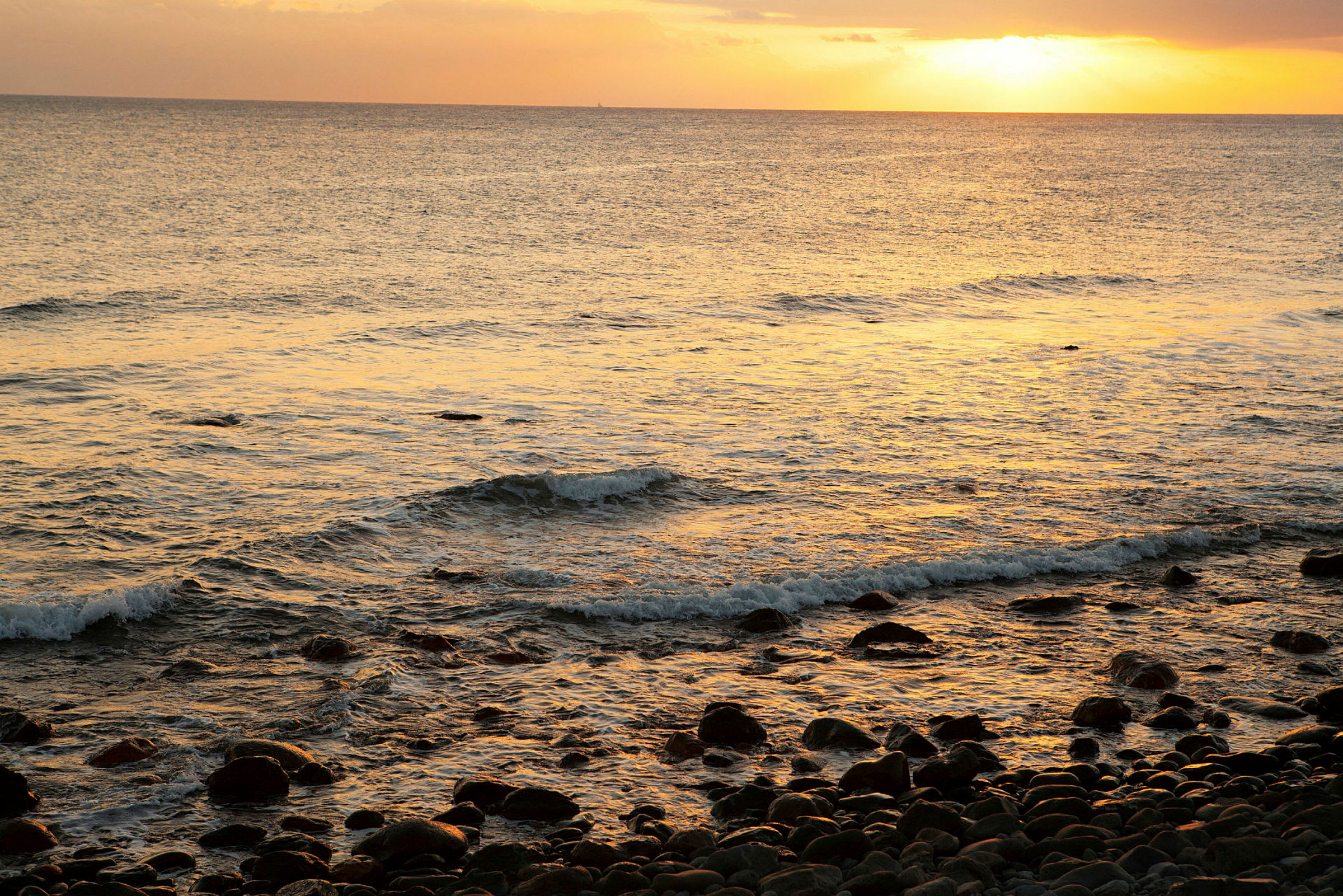 En strand med steiner ved solnedgang. (AI-generert tekst)