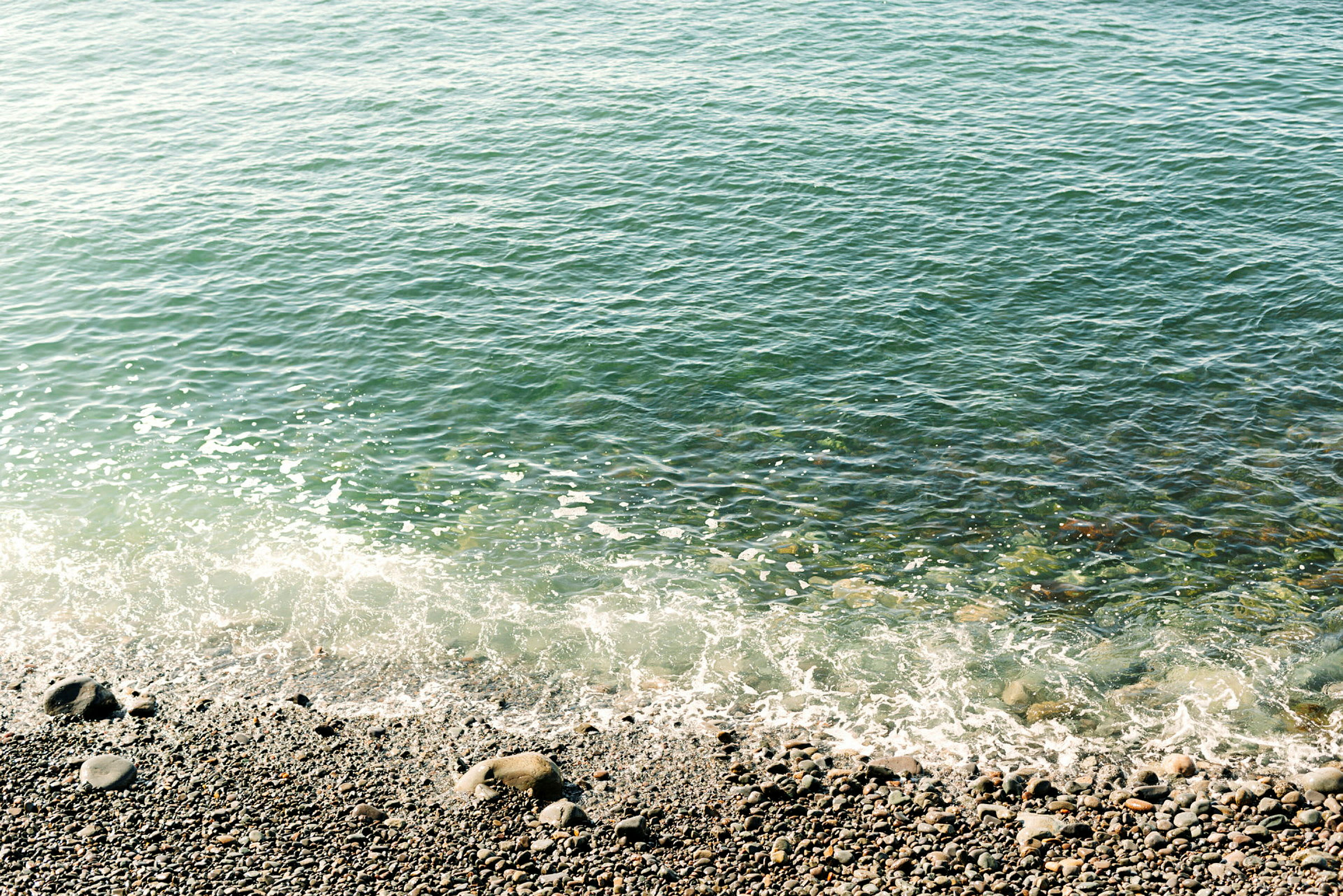 Bilde av en steinete kystlinje der vann møter stranden. (AI-generert tekst)