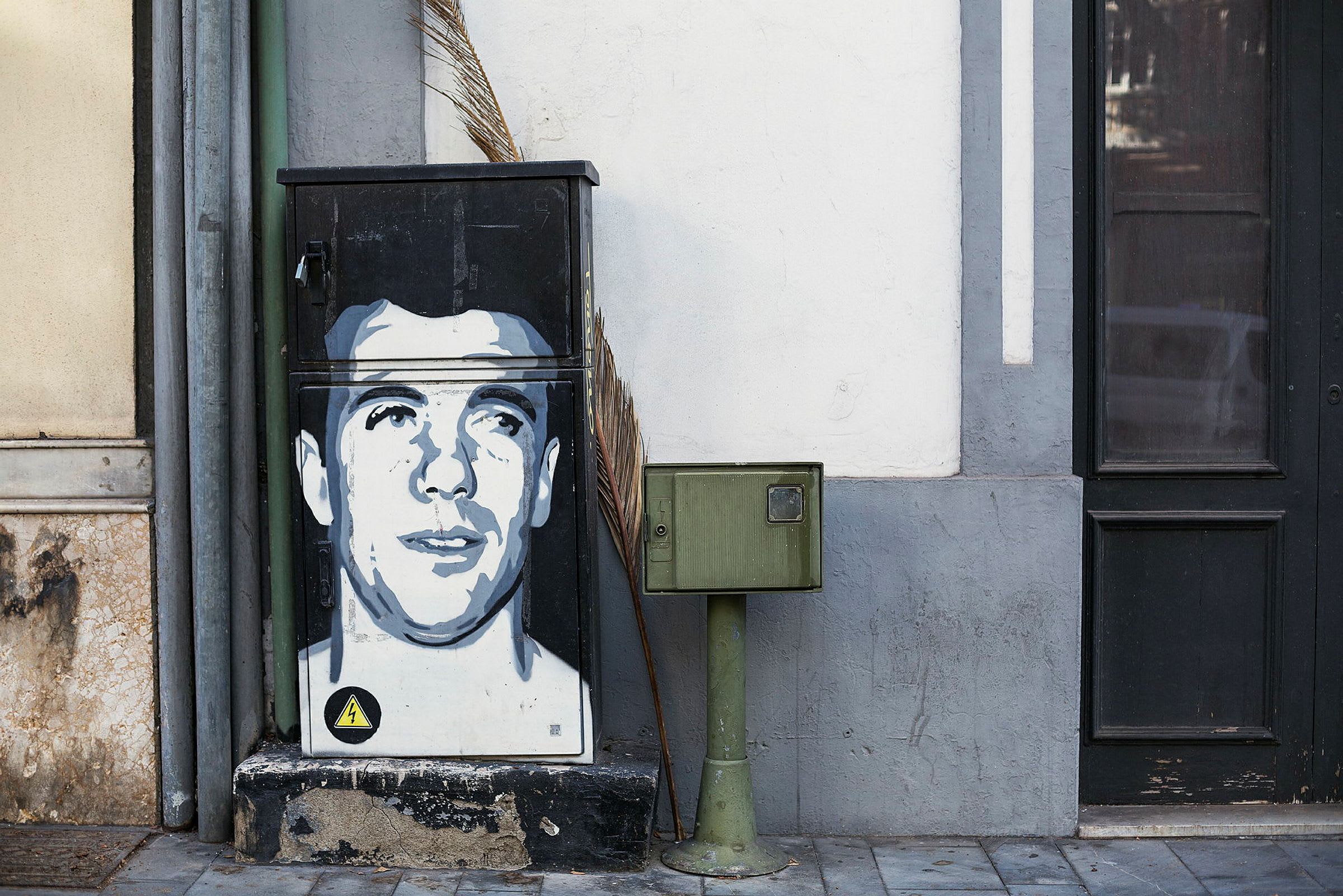Et elektrisk skap med grafitti ved siden av en postkassetolpe. (AI-generert tekst)