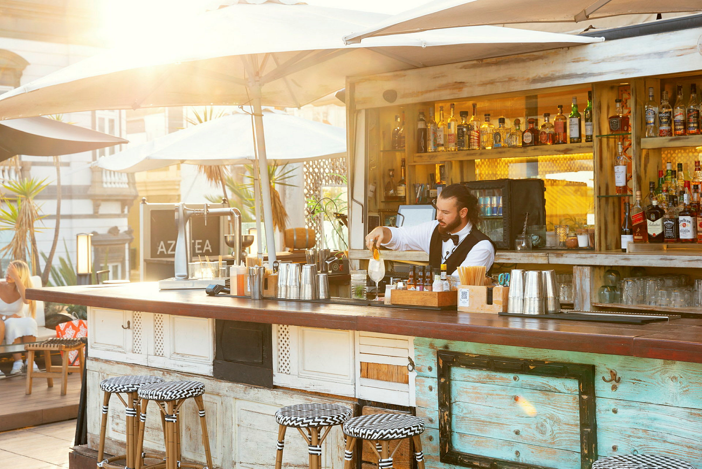 Utendørs bar med parasoller og sitteplasser ved baren. (AI-generert tekst)