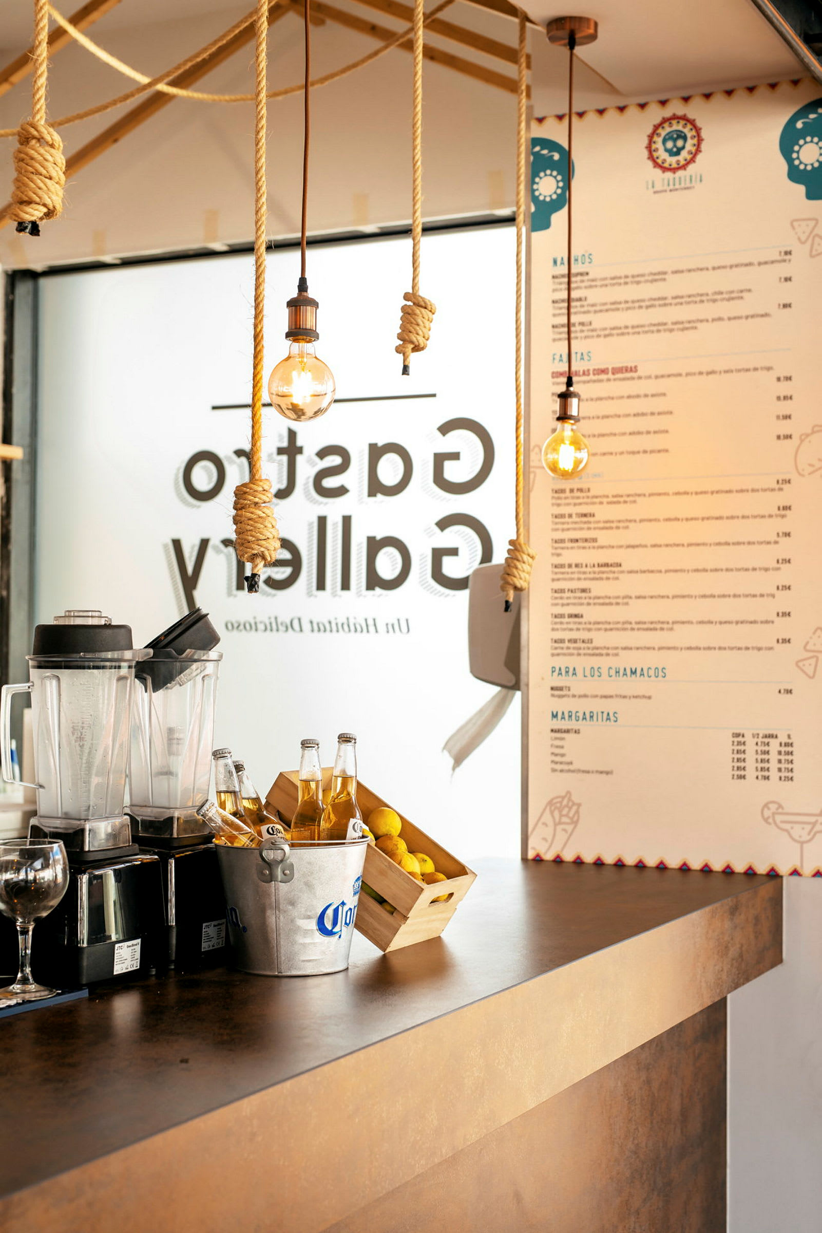Disk i en restaurant med blender, ølspann, sitroner og meny på veggen. (AI-generert tekst)