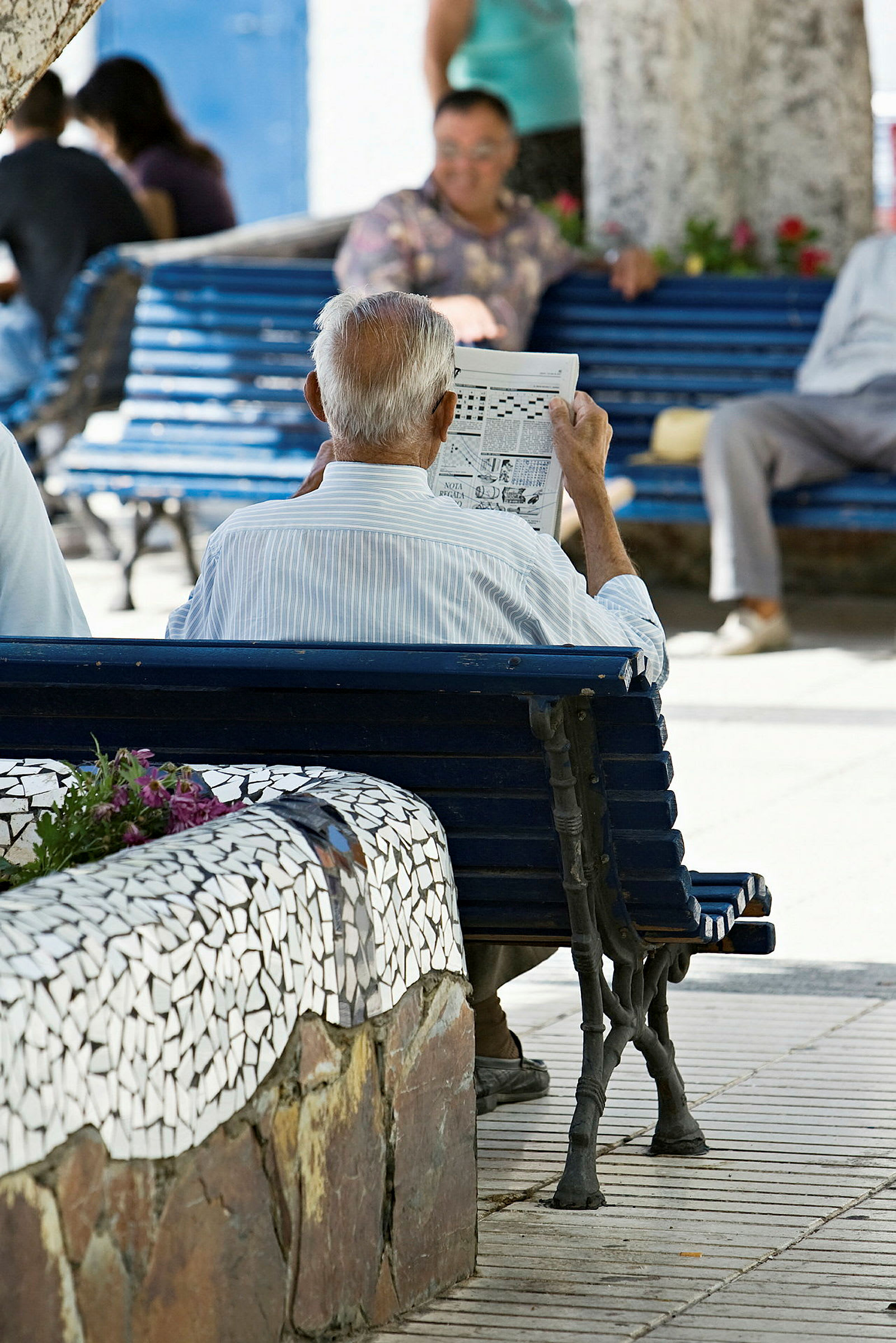 En eldre mann sitter på en parkbenk og leser en avis. (AI-generert tekst)