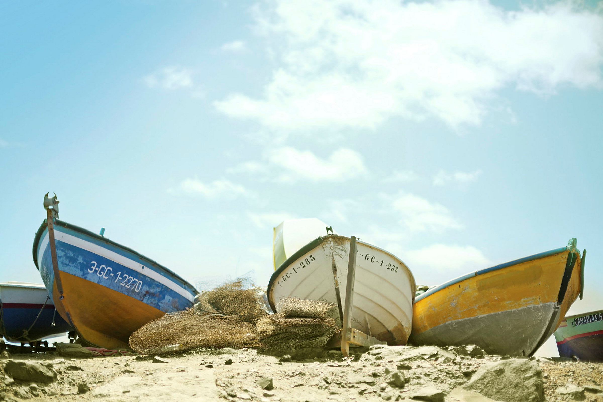 Flere små båter står oppstilt på en strand. (AI-generert tekst)