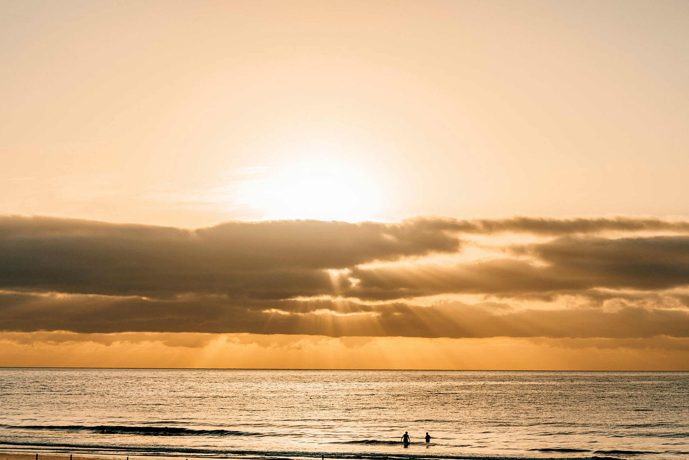 En strand med havet ved solnedgang. (AI-generert tekst)