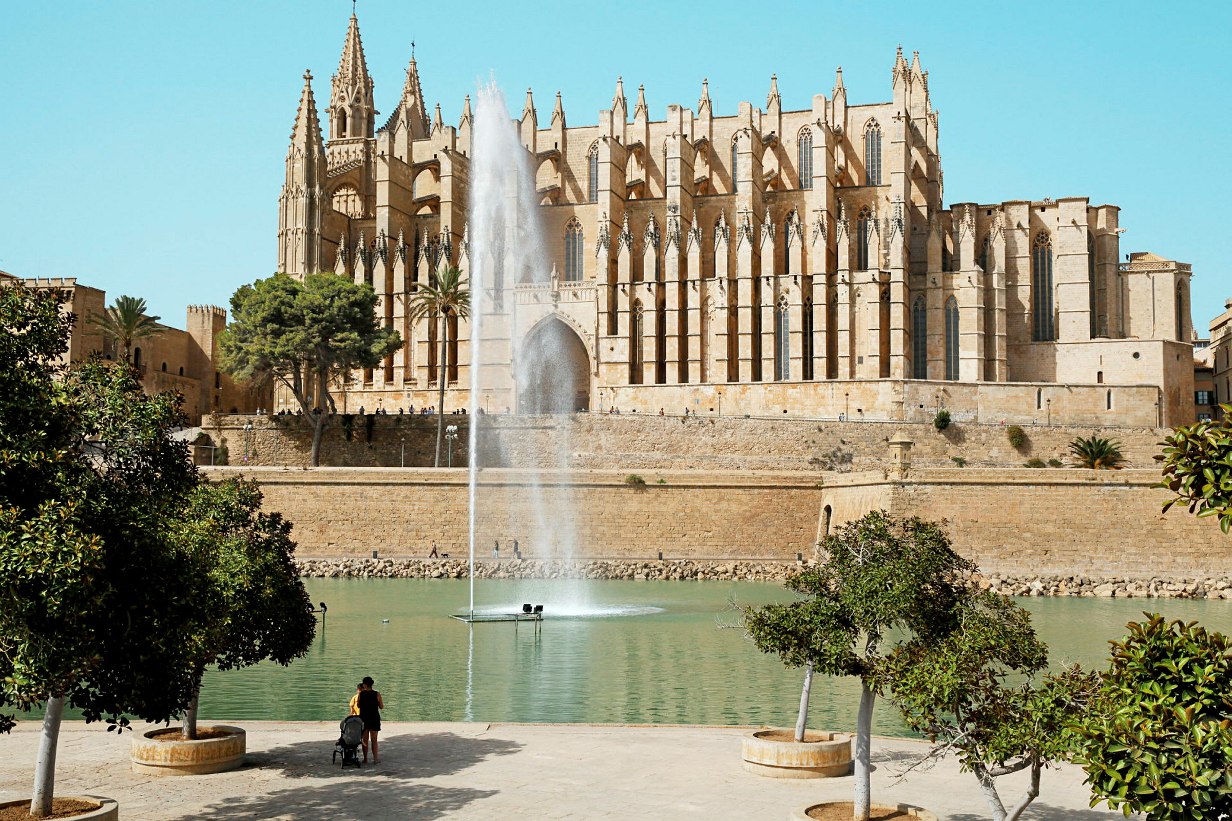 Gotisk katedral i Palma de Mallorca med fontene og grønt område i forgrunnen. (AI-generert tekst)