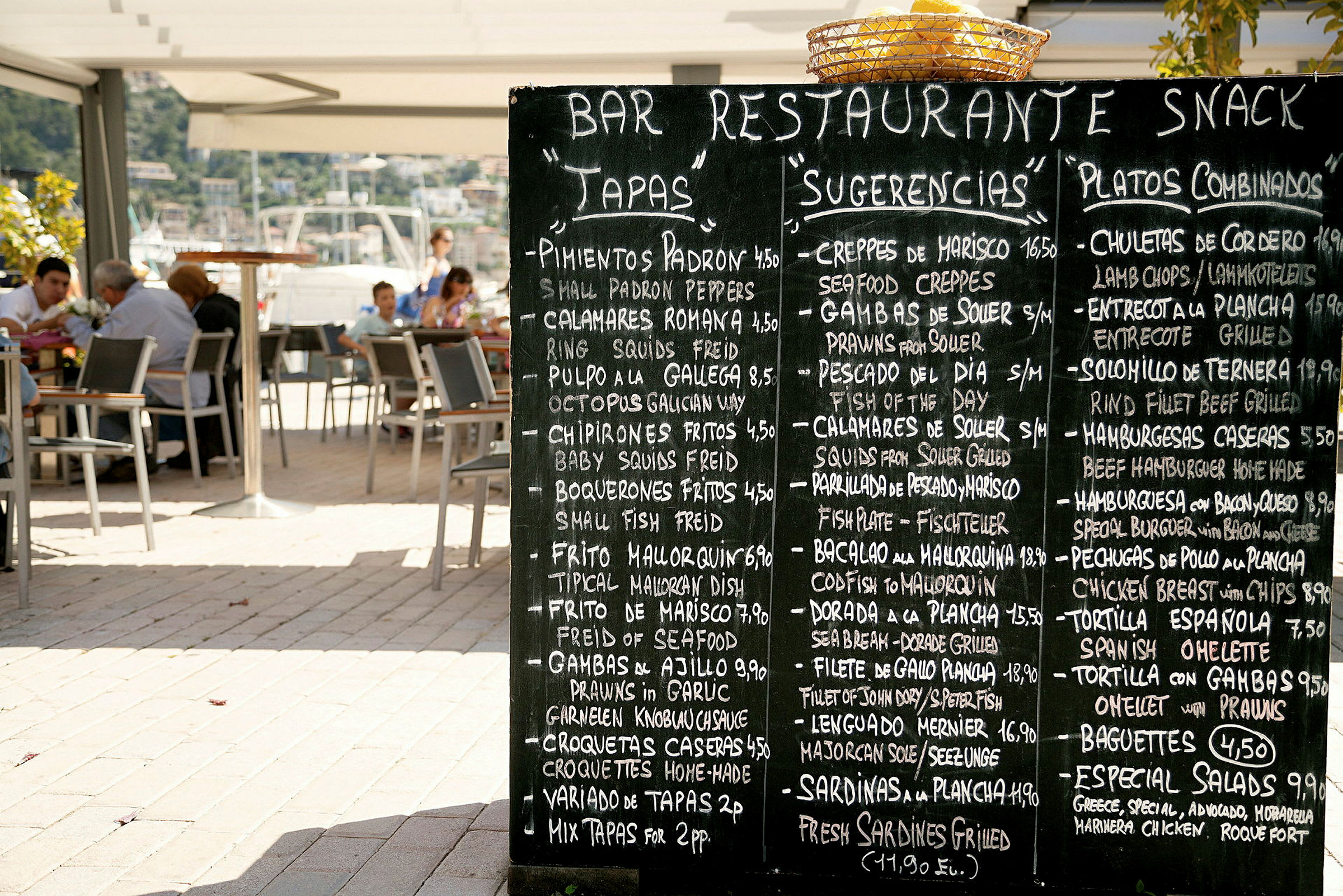 Svart tavle med en meny på en restaurantterrasse. (AI-generert tekst)
