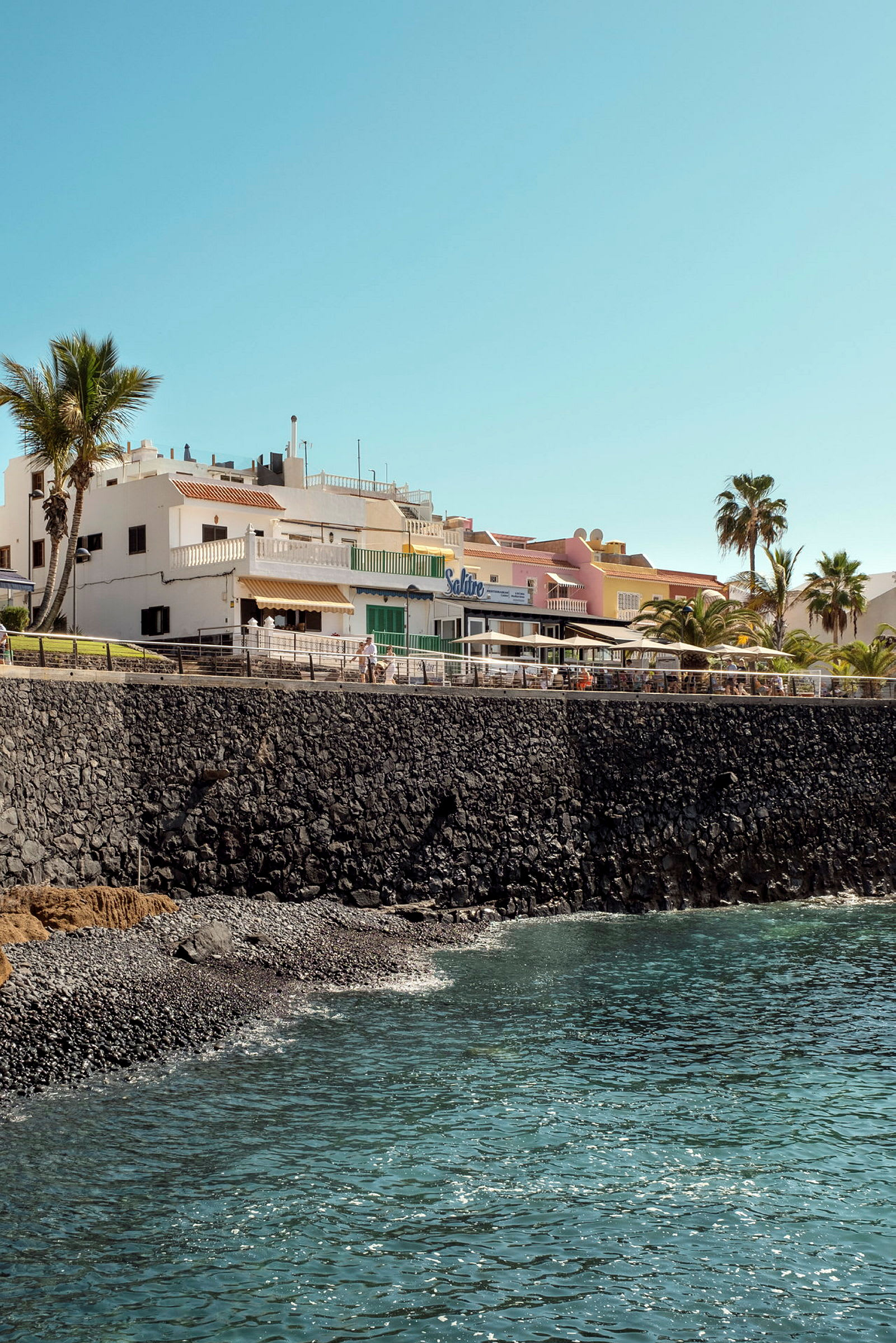 Strandpromenade med bygninger nær havet. (AI-generert tekst)