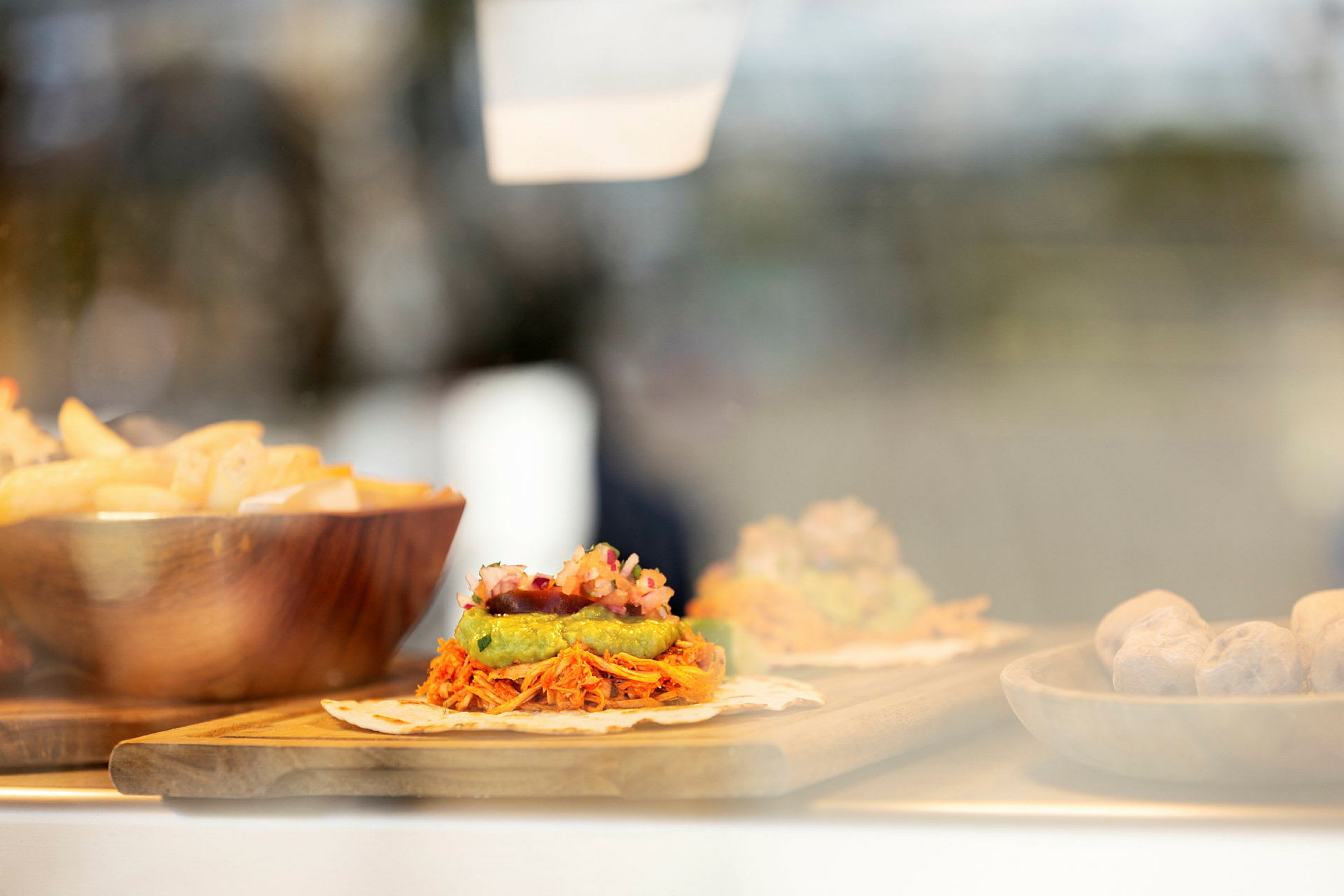 Mat som består av tortilla med topping, pommes frites i en skål og andre tilbehør. (AI-generert tekst)