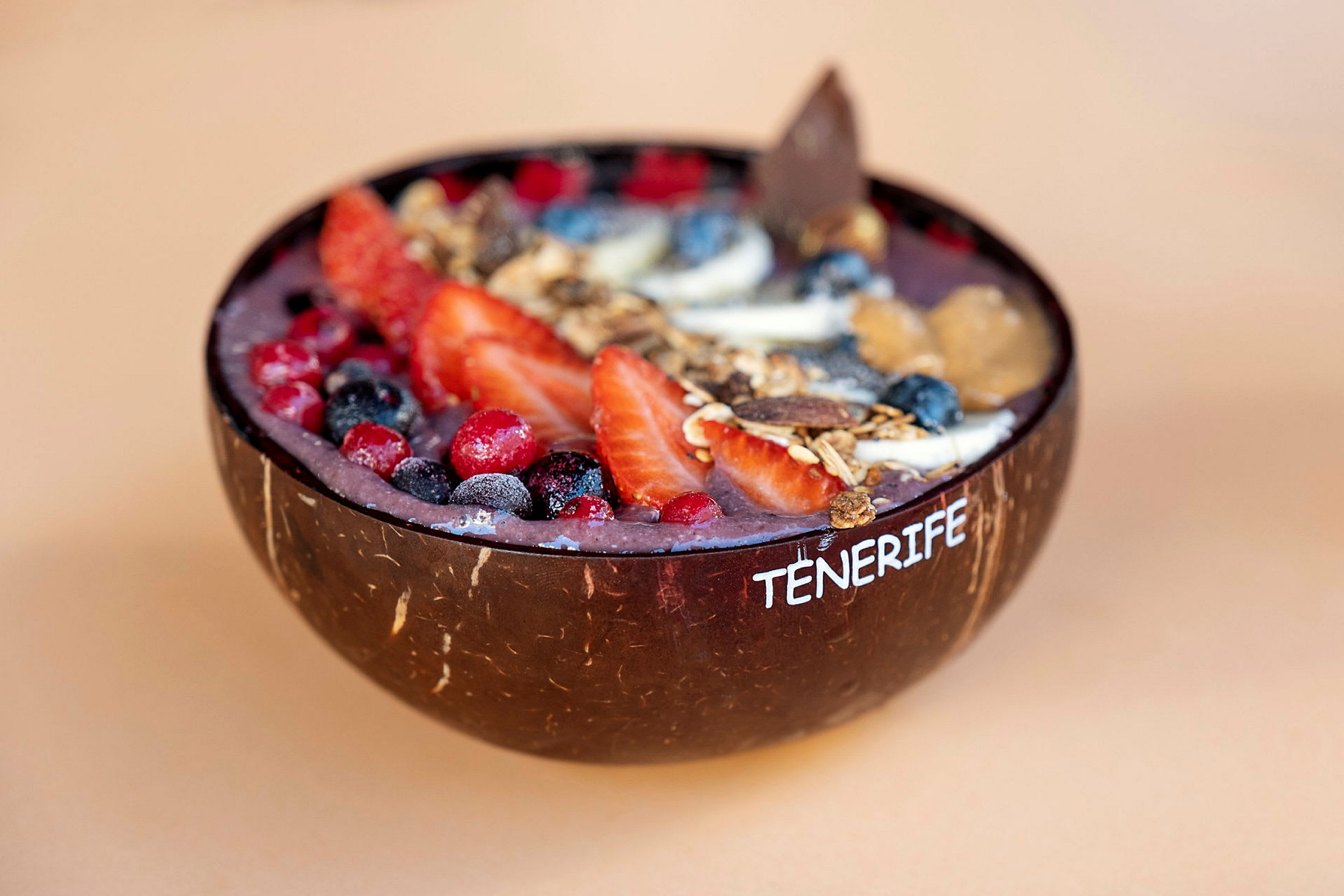En acai-bolle med bær og granola servert i en kokosnøttskål. (AI-generert tekst)