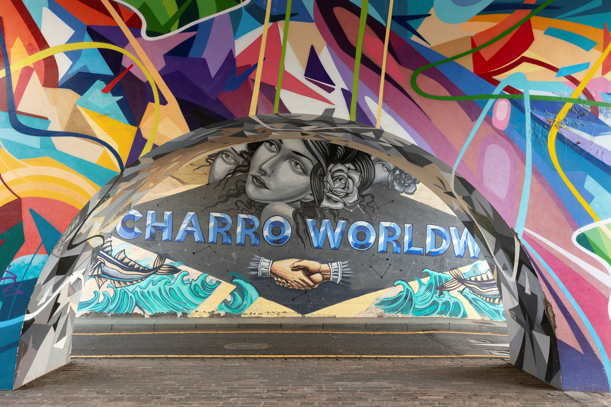 Et fargerikt veggmaleri med teksten 'Charro World', håndtrykk og strandmotiv. (AI-generert tekst)