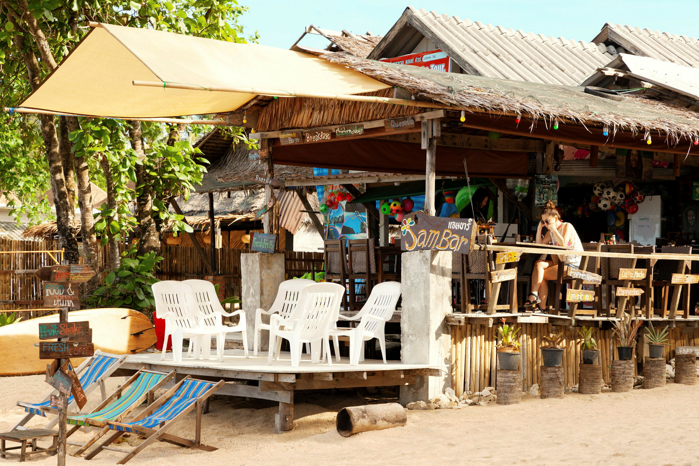 En strandkafé med plaststoler og fargerike dekorasjoner. (AI-generert tekst)