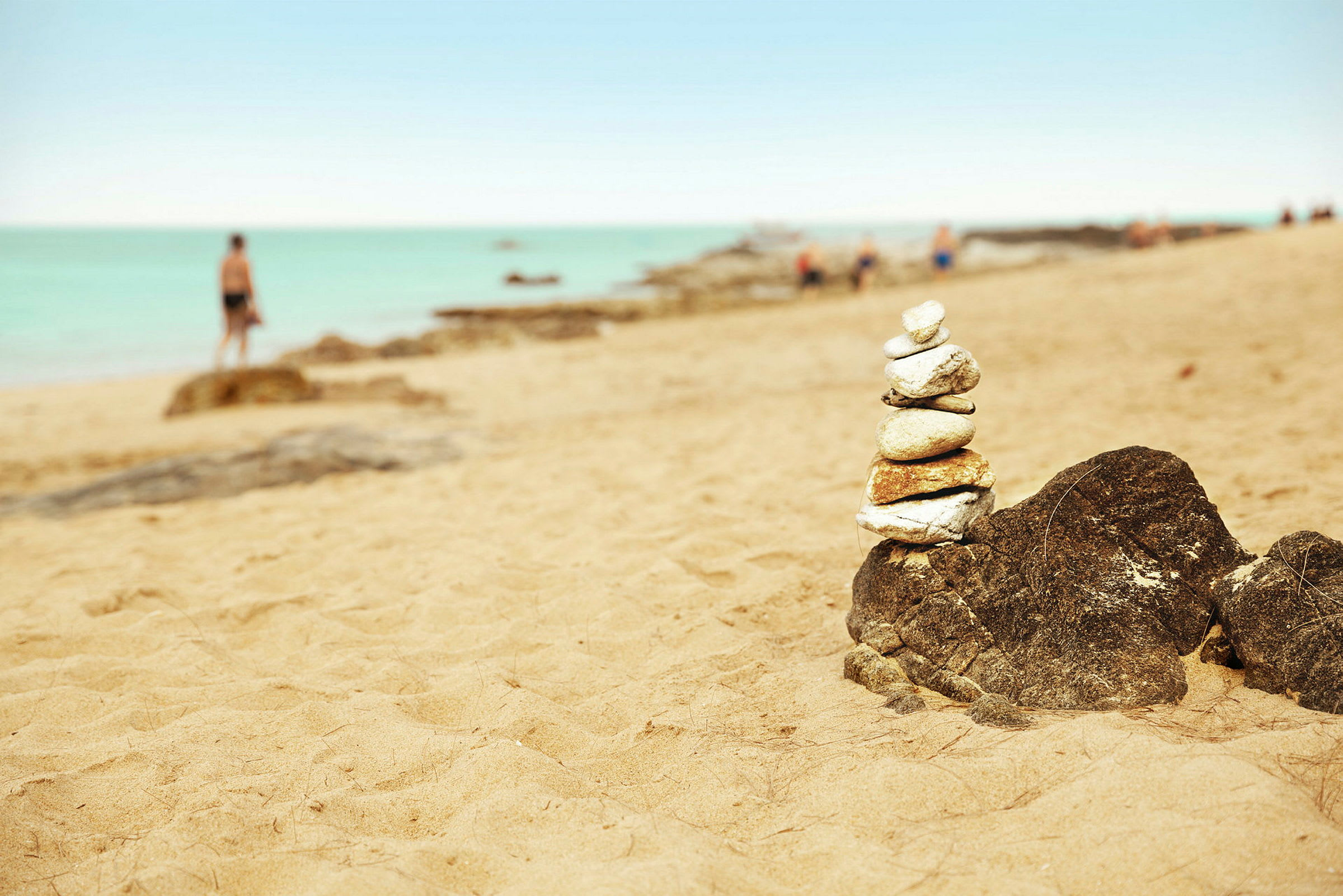 Steiner stablet på en strand med havet i bakgrunnen. (AI-generert tekst)