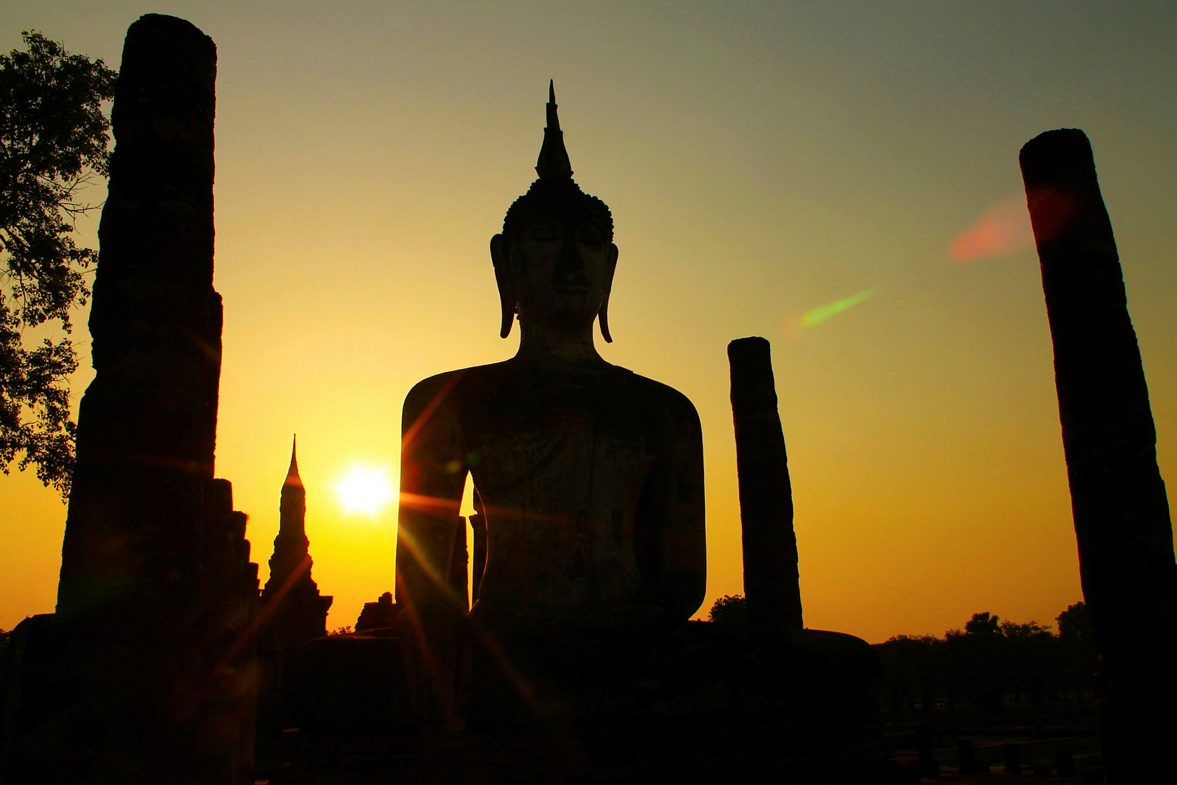 Buddhastatue i solnedgangen i Sukhothai