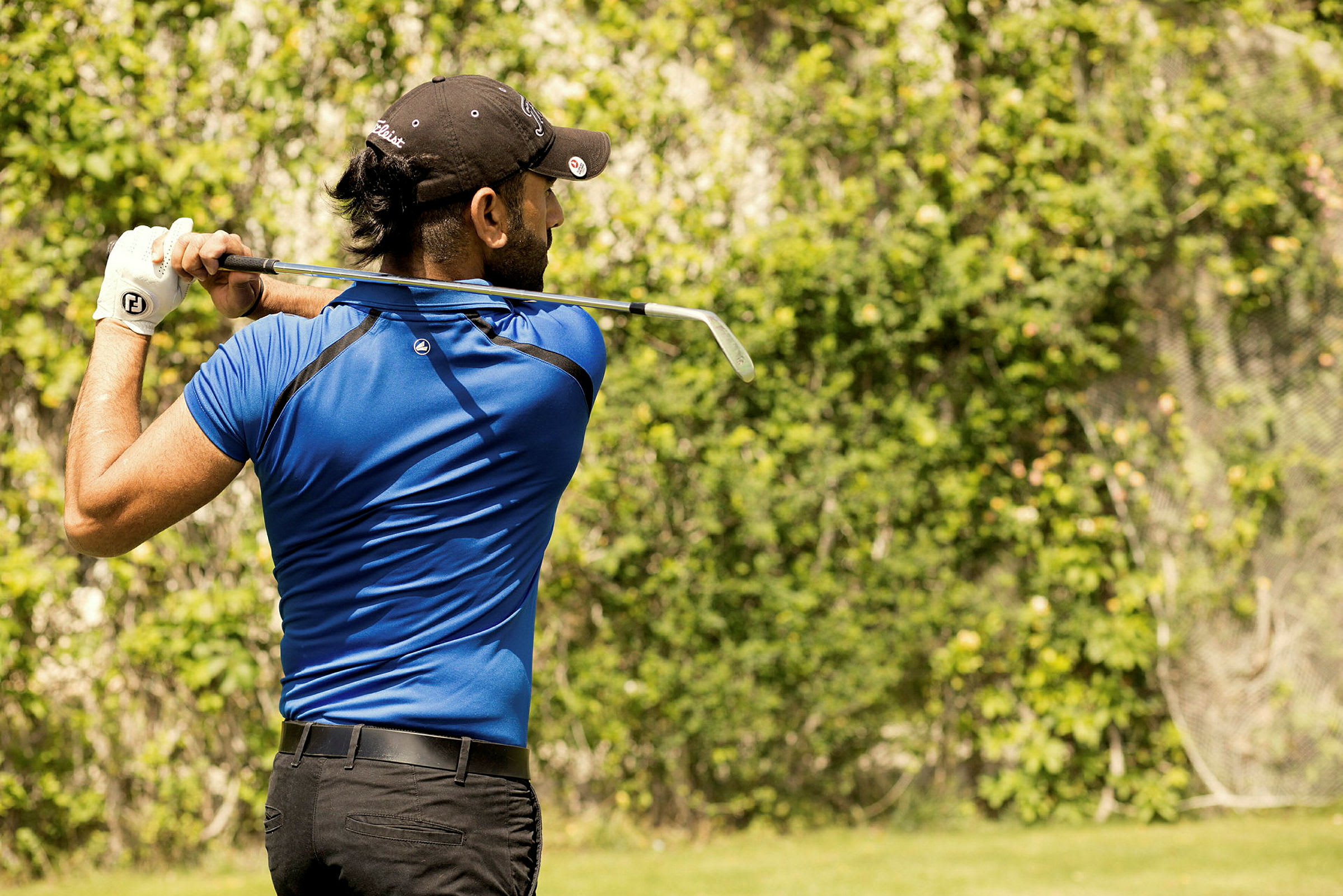 En person som spiller golf på en grønn plass. (AI-generert tekst)