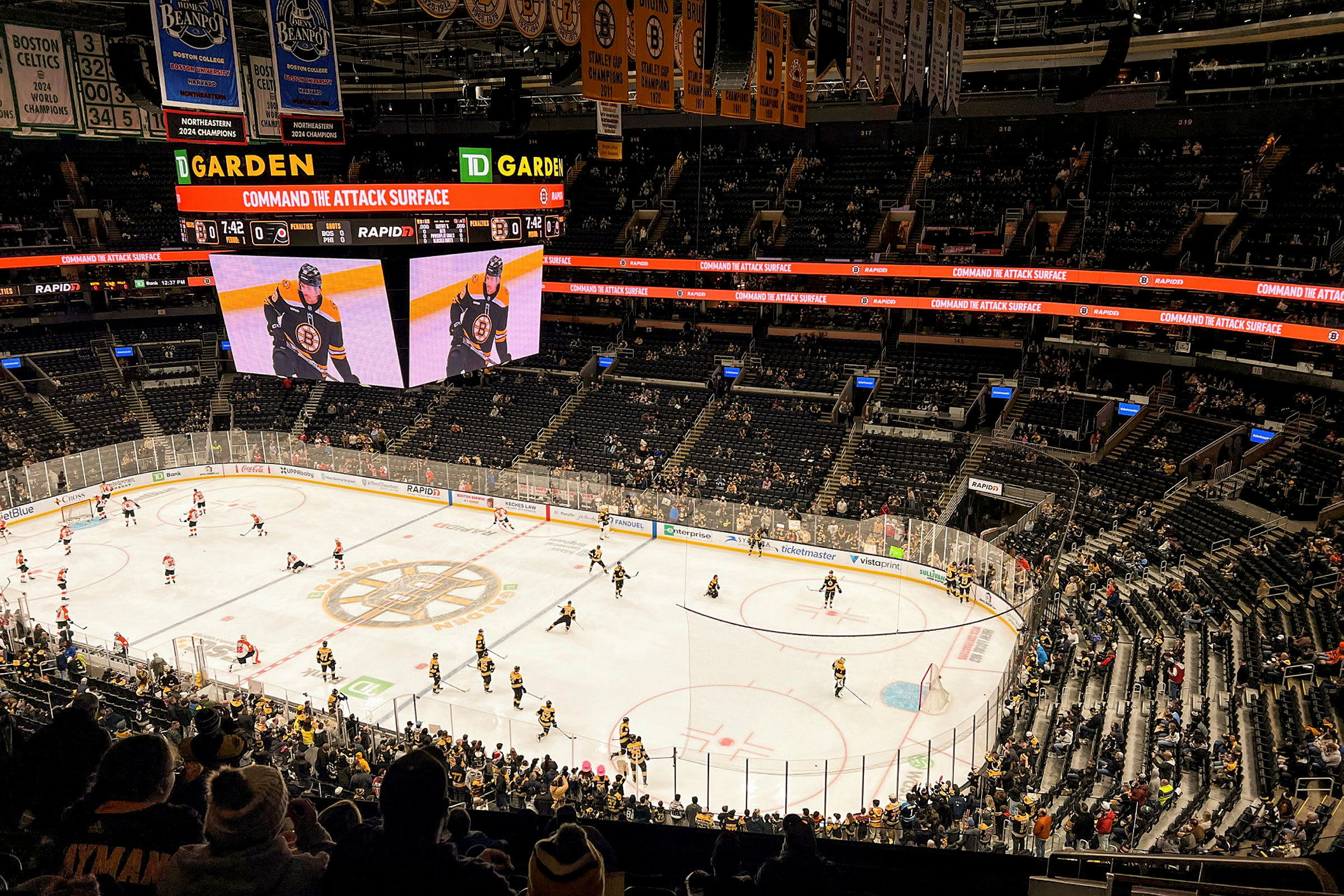 En ishockeykamp foregår i en stor arena med mange tilskuere. (AI-generert tekst)