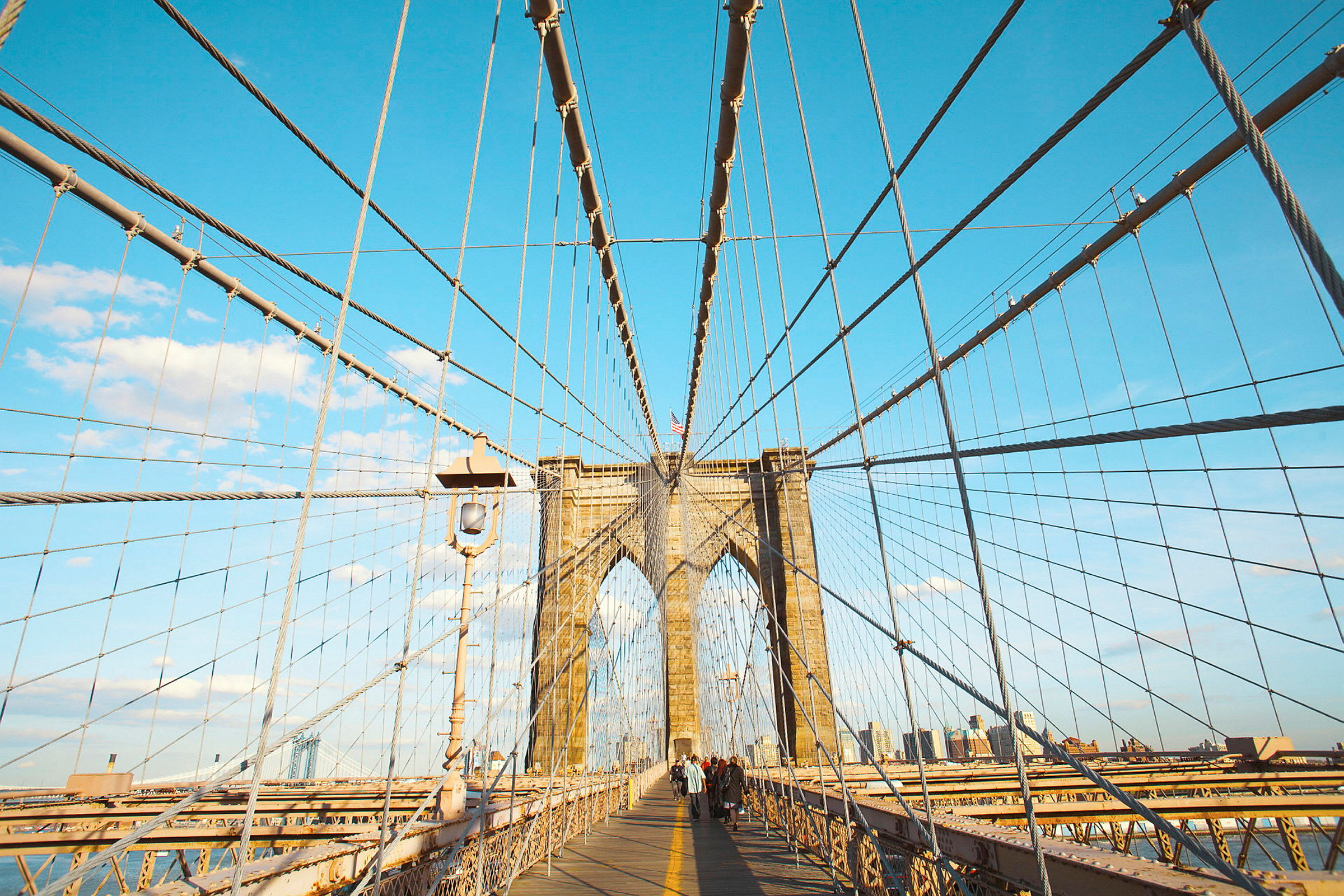 Brooklyn Bridge med vaiere og folk som går på gangveien. (AI-generert tekst)