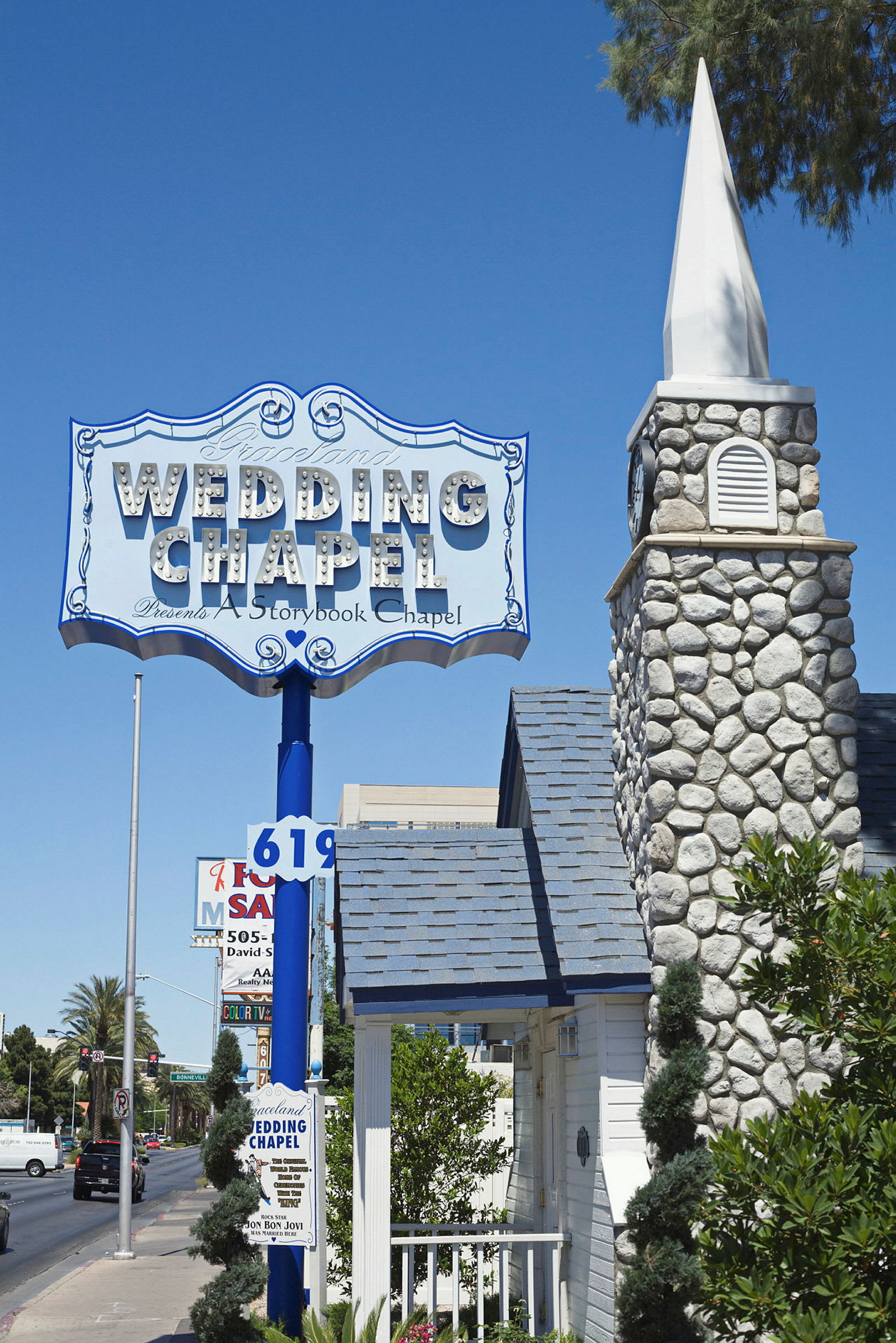 Et skilt med teksten 'Wedding Chapel' over en steinkirkes bygning, med en blå himmel i bakgrunnen. (AI-generert tekst)