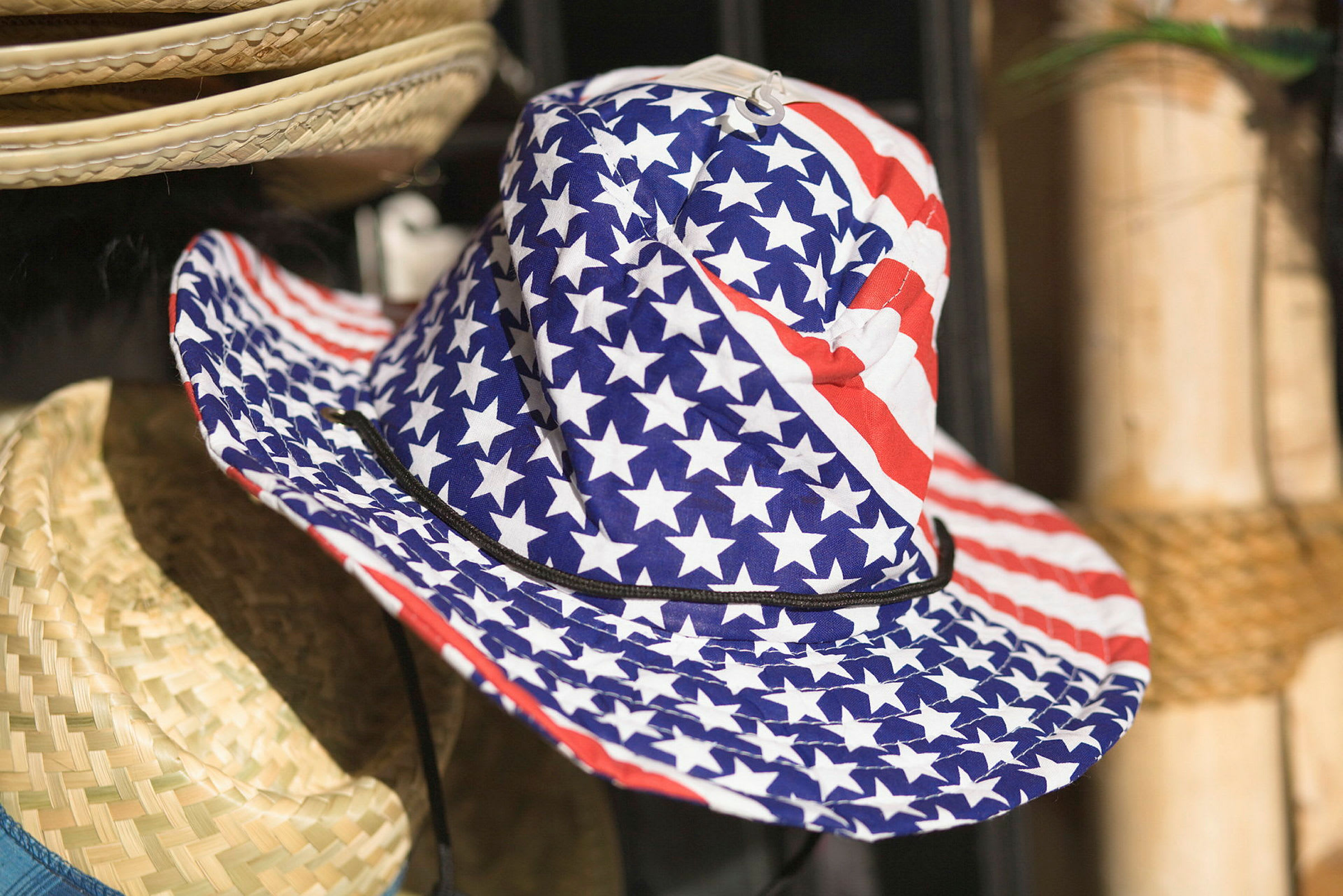 En hatt med et mønster av det amerikanske flagget henger ved siden av andre hatter. (AI-generert tekst)