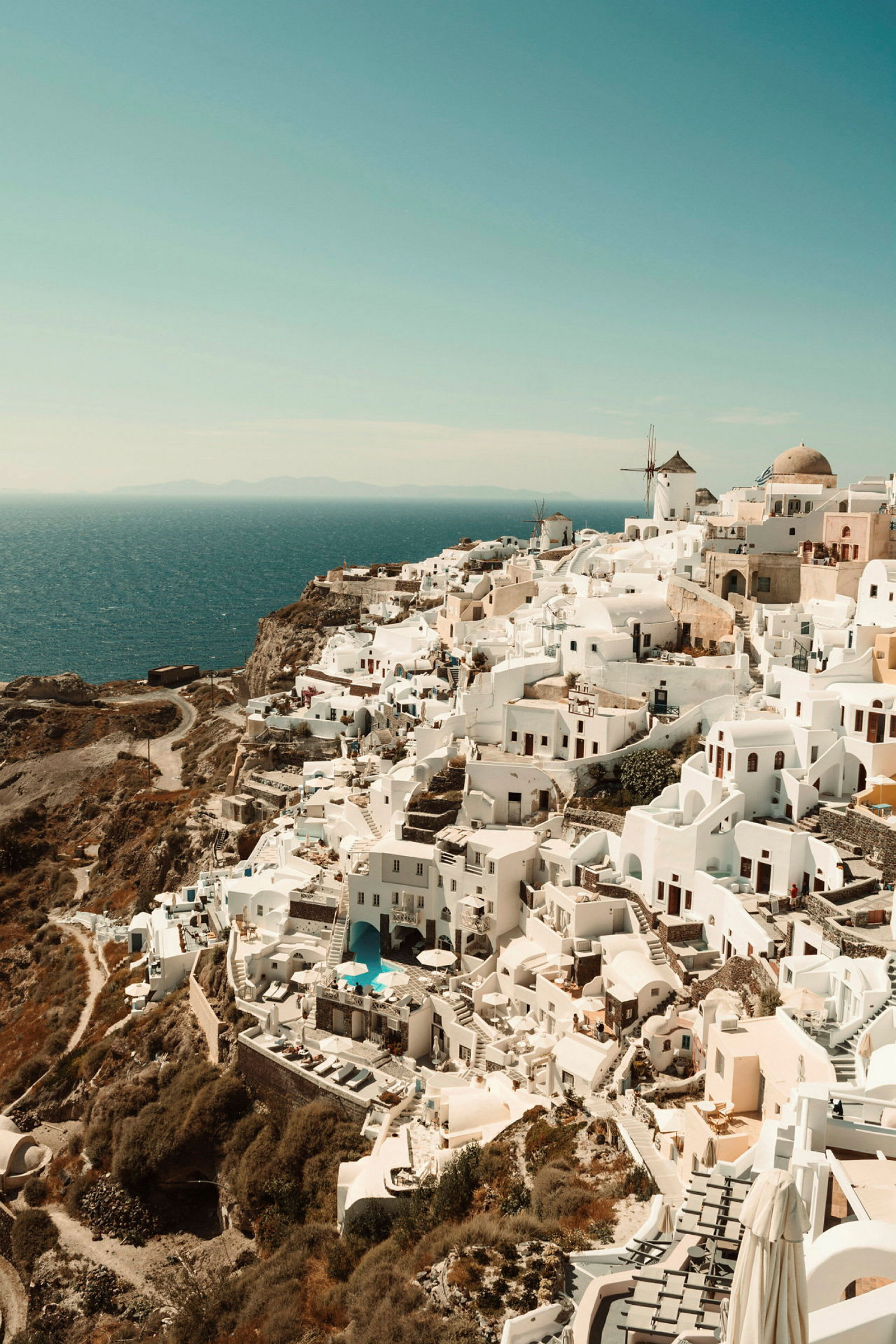 Utsikt over hvite hus og bygninger på en klippe ved havet, typisk for Santorini. (AI-generert tekst)