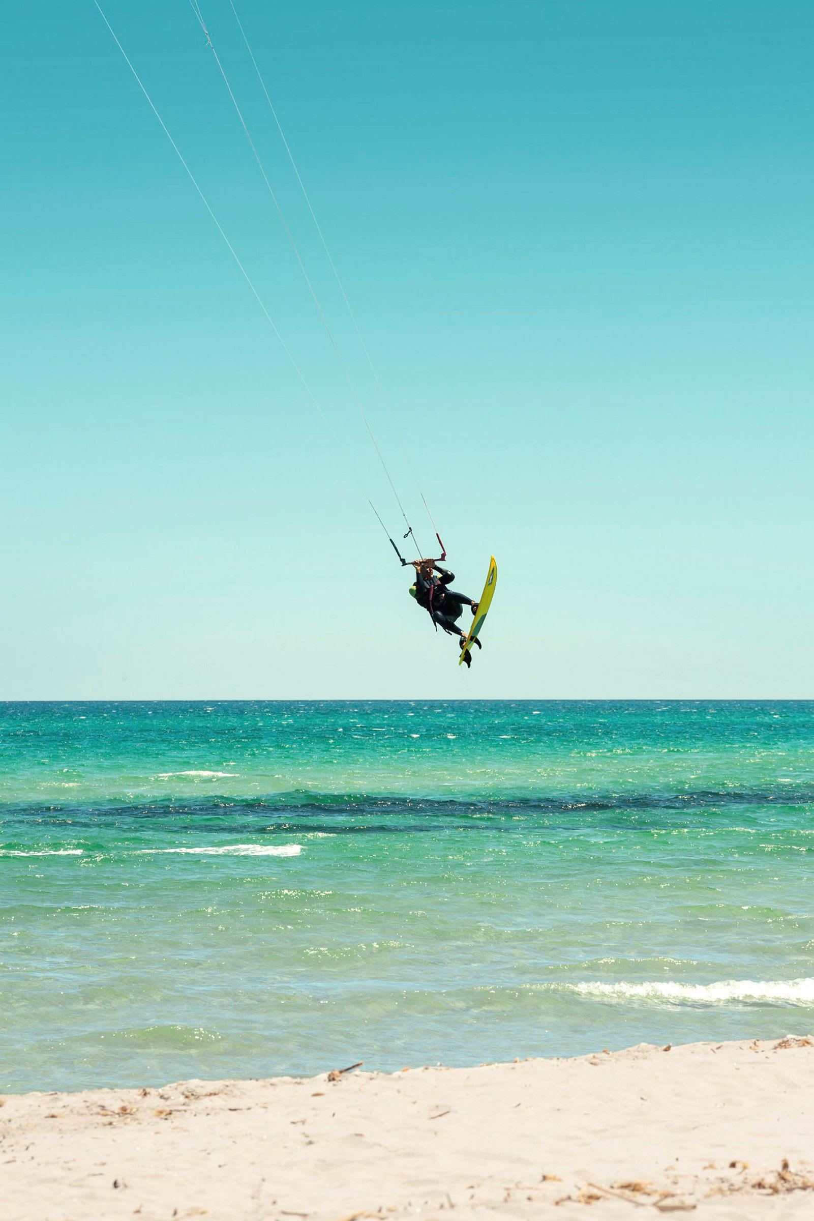 Person kitesurfer på et blågrønt hav. (AI-generert tekst)