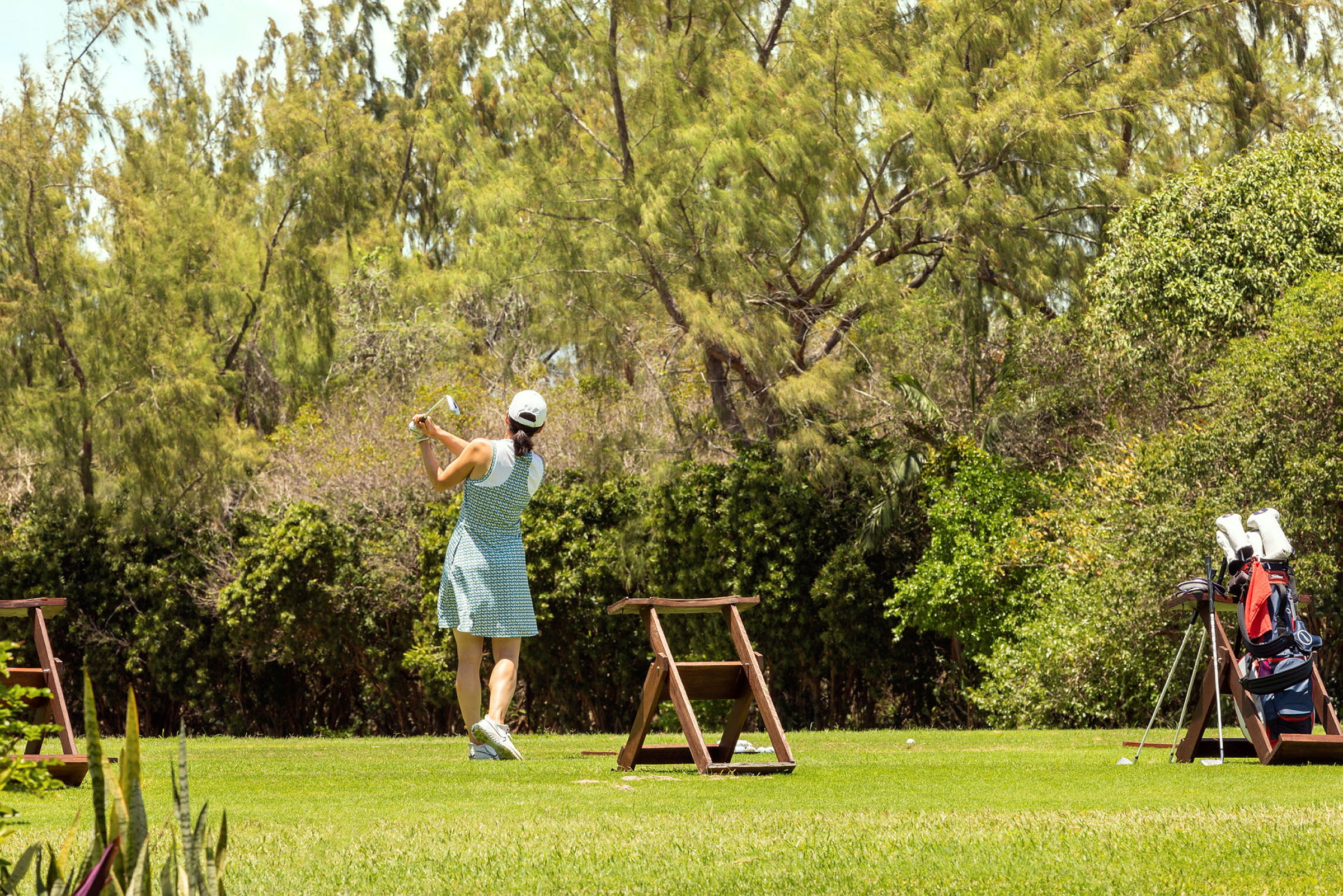 En person som spiller golf på et grønt område. (AI-generert tekst)