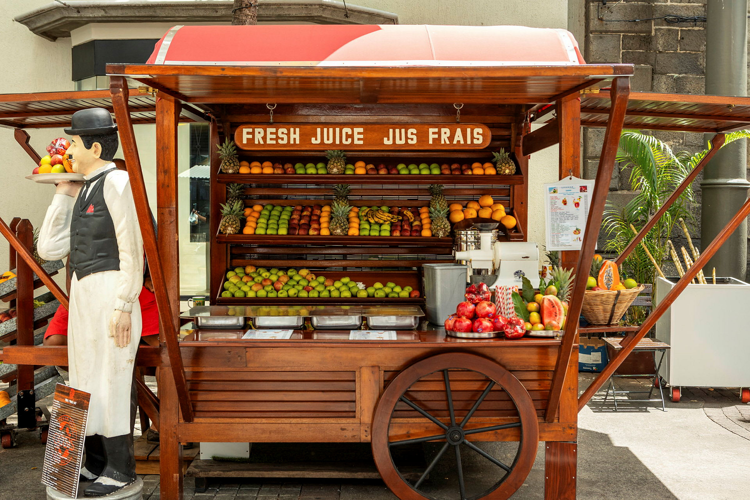 Et fruktbod med fersk frukt og en juicepresse. (AI-generert tekst)