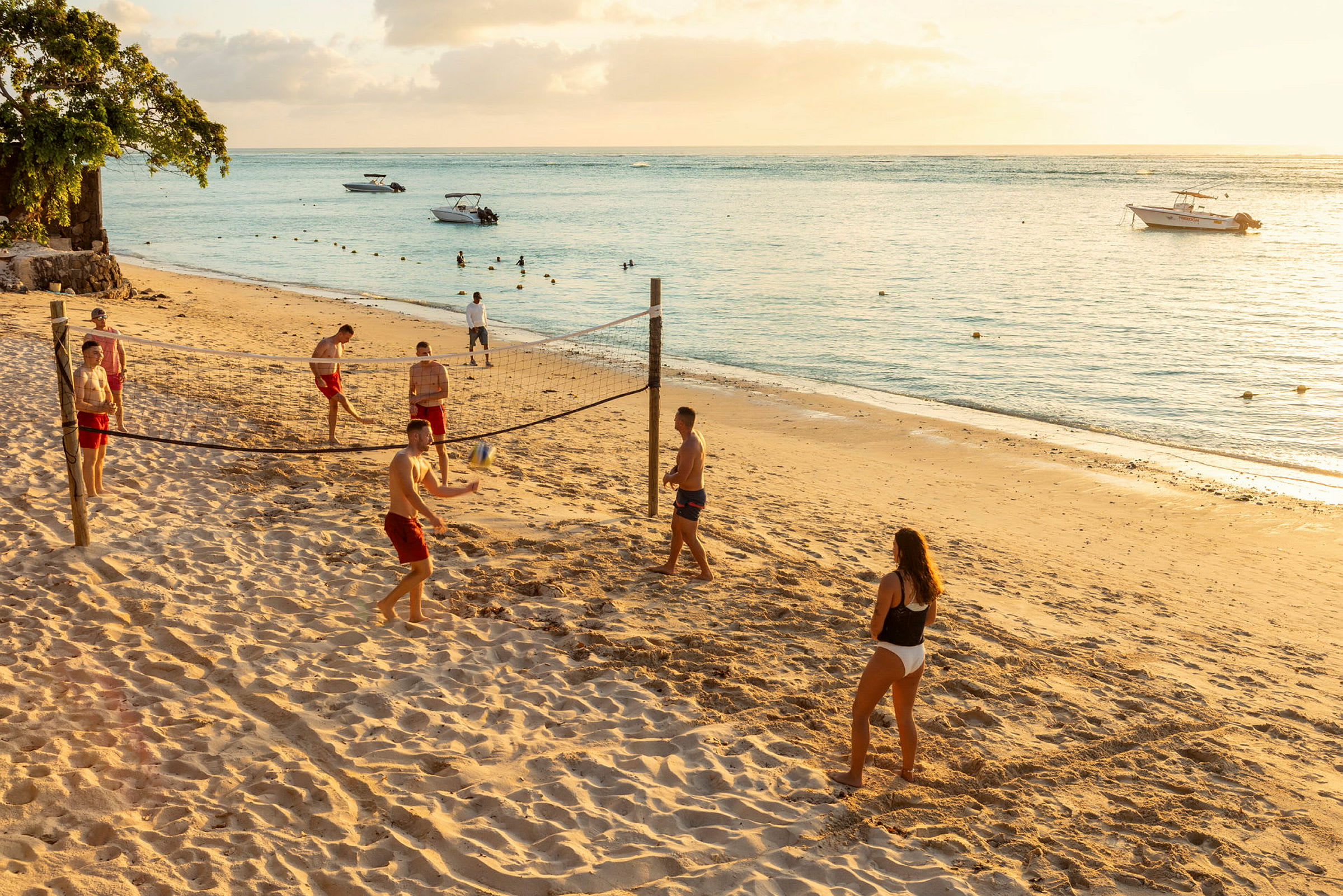 Personer spiller volleyball på en sandstrand ved havet. (AI-generert tekst)