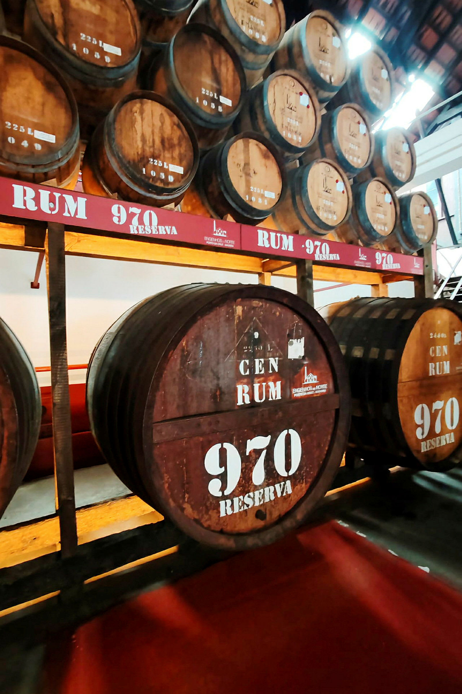 Flere store trefat på en lagringshylle, merket med teksten 'Rum 970 Reserva'. (AI-generert tekst)