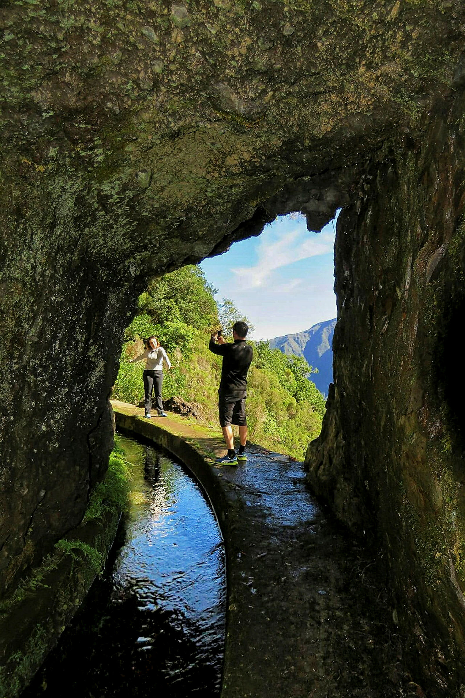 Person står ved bergtunnel og fotograferer landskap. (AI-generert tekst)