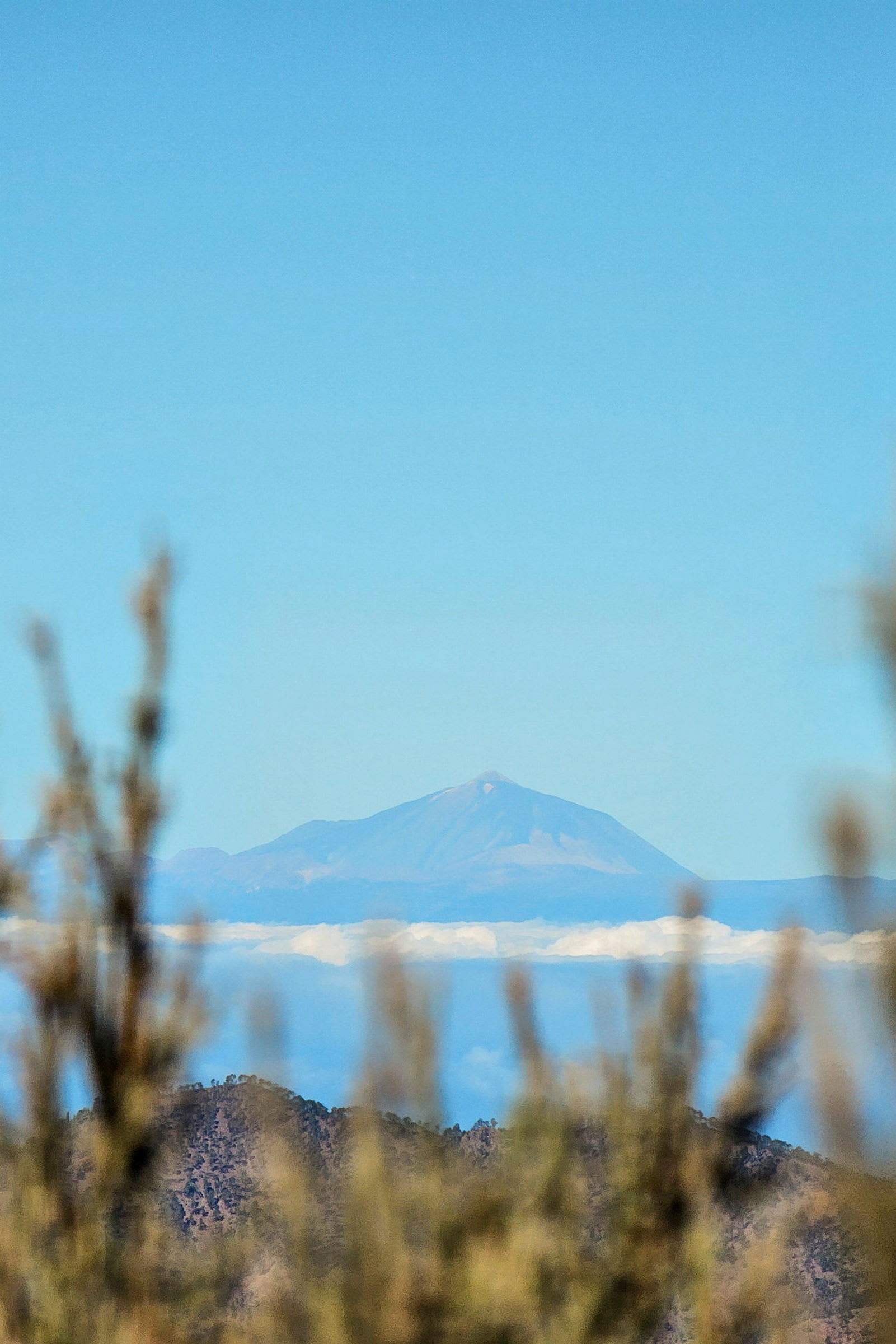 Utsikt over et fjell med blå himmel og skyer. (AI-generert tekst)