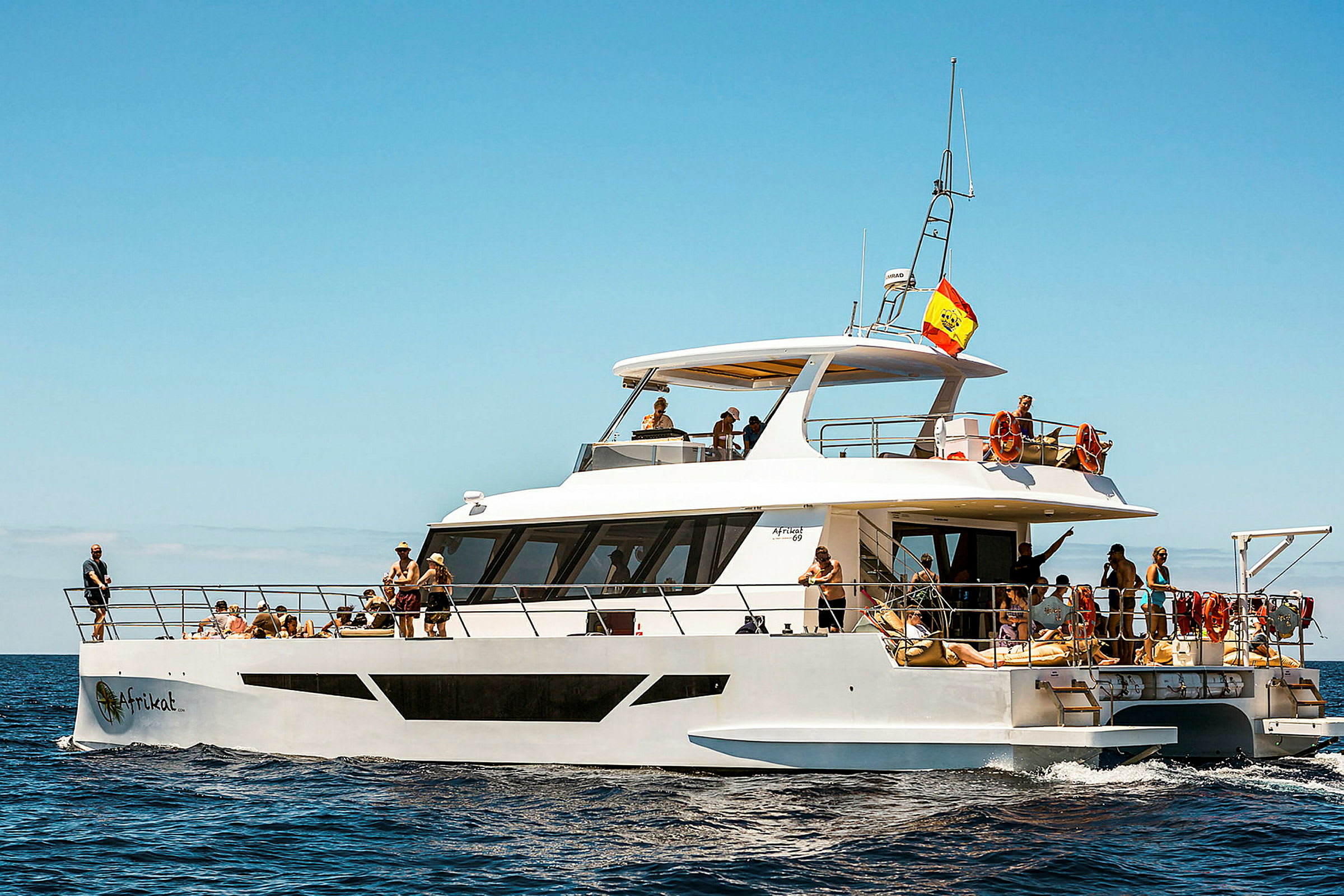 En hvit motorbåt med personer som nyter en solrik dag på havet. (AI-generert tekst)