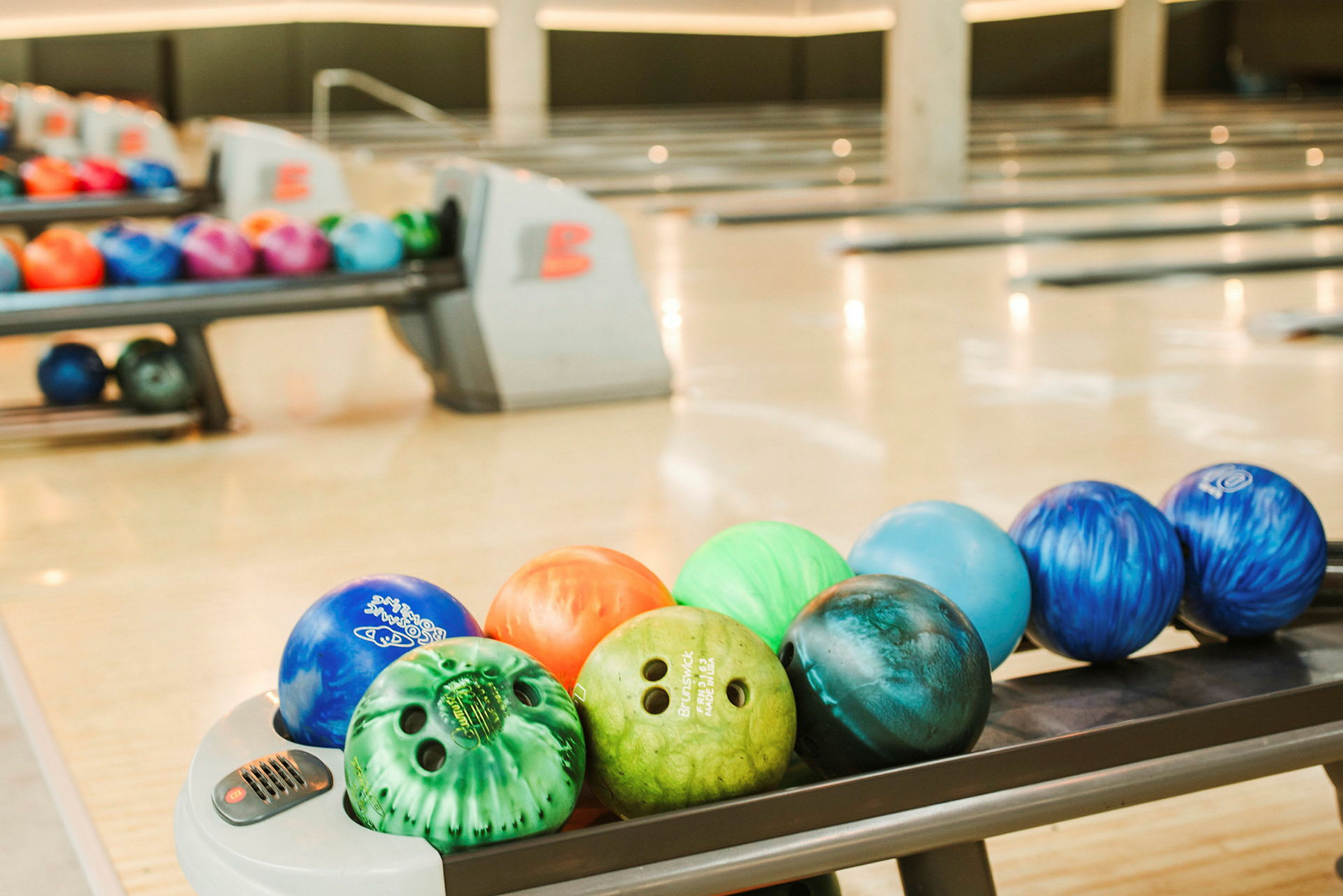 Bowlingkuler i forskjellige farger på banene i en bowlinghall. (AI-generert tekst)