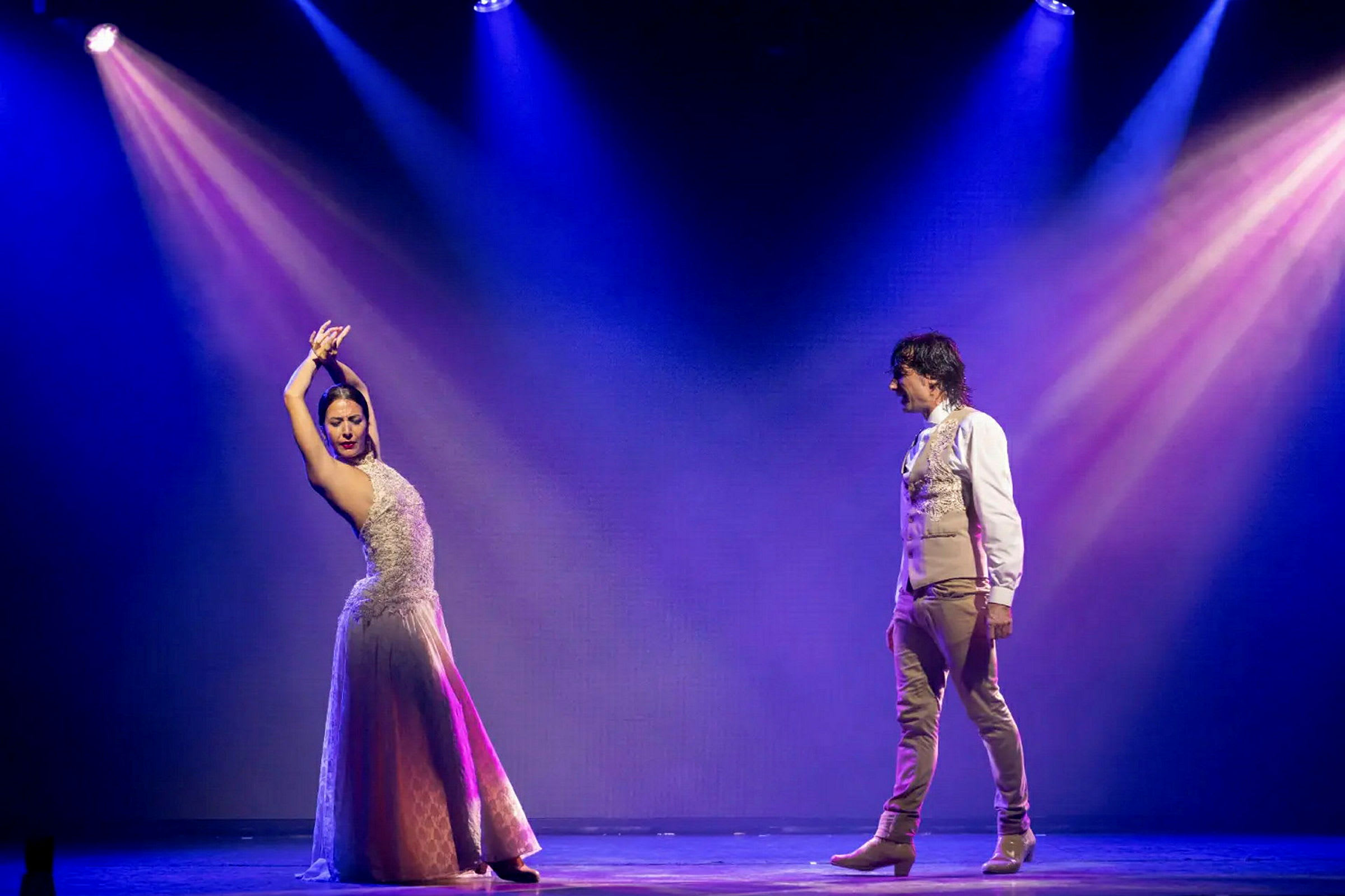 To personer danser på en scene med fargerike lyskastere. (AI-generert tekst)