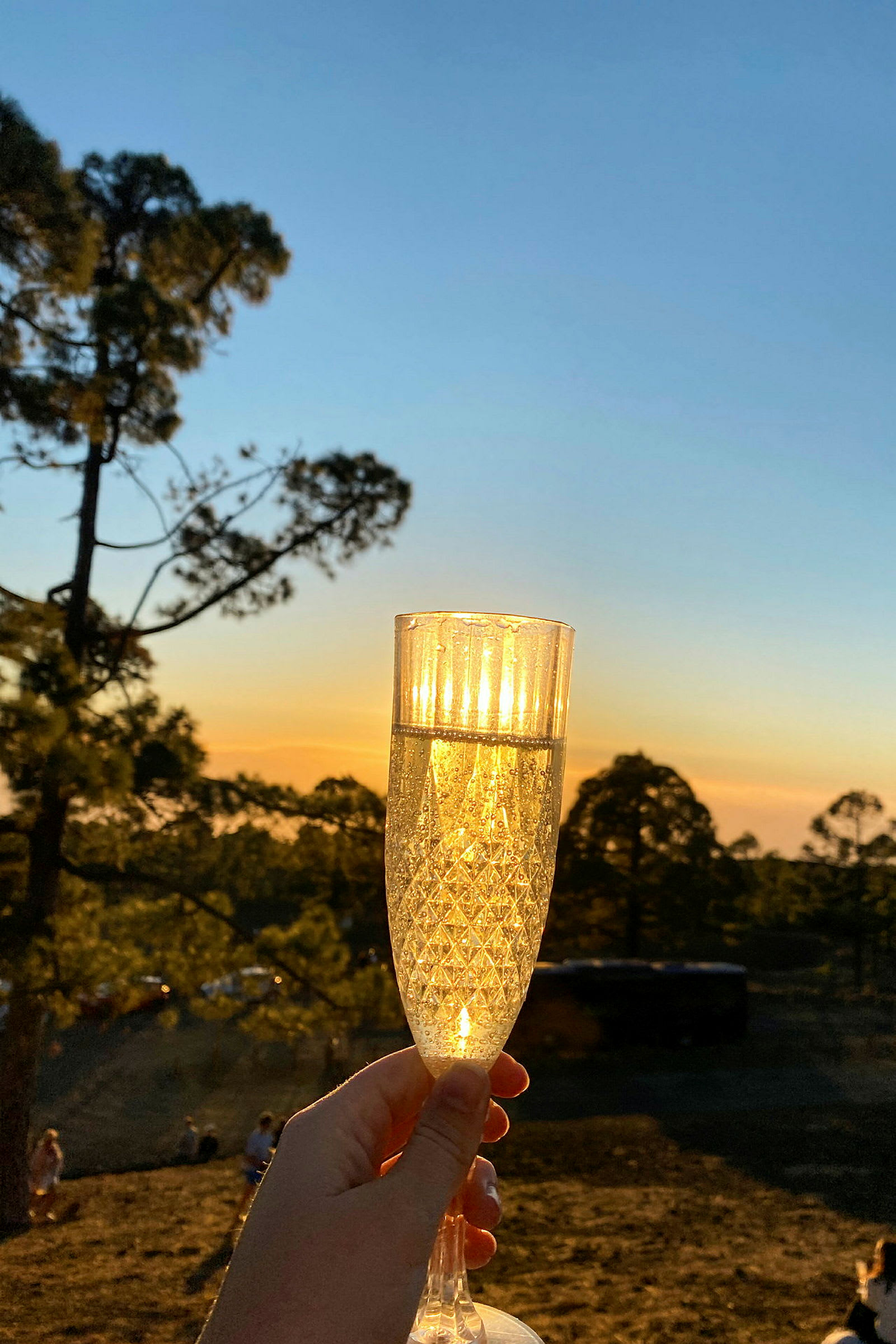 Et glass bobler i en hånd med solnedgang og natur i bakgrunnen. (AI-generert tekst)